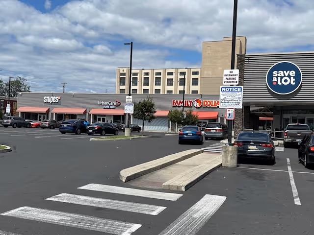 Exterior view of a strip mall with UrbanCare Home Care storefront and parking