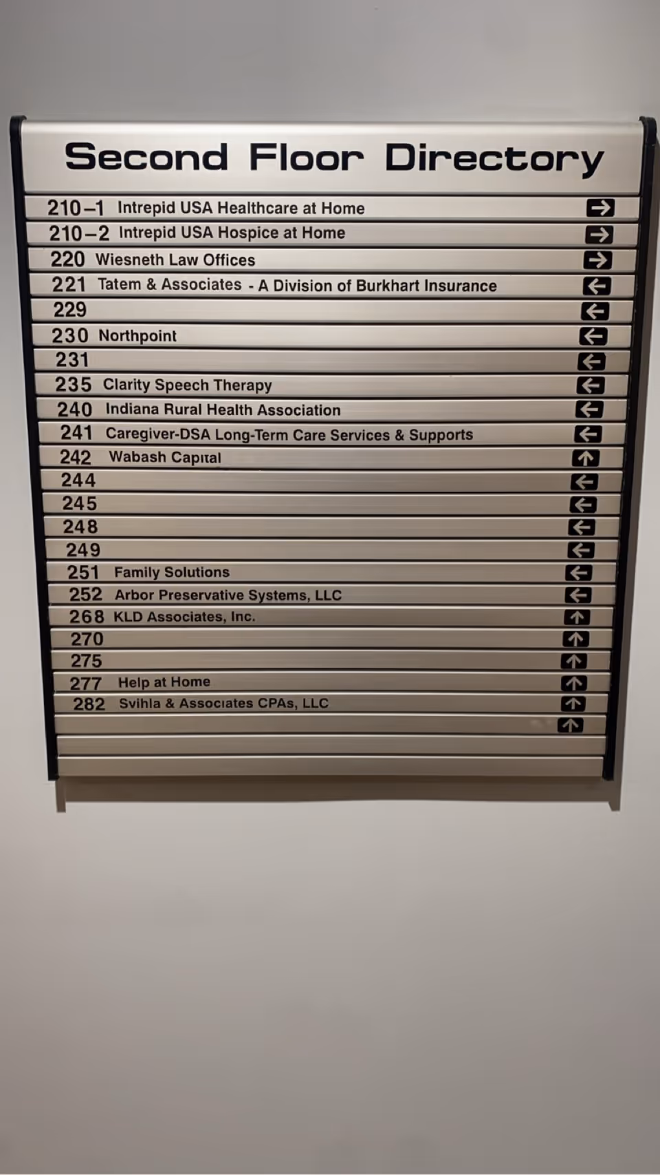 Second floor directory sign listing offices, including Help at Home, mounted on a wall.