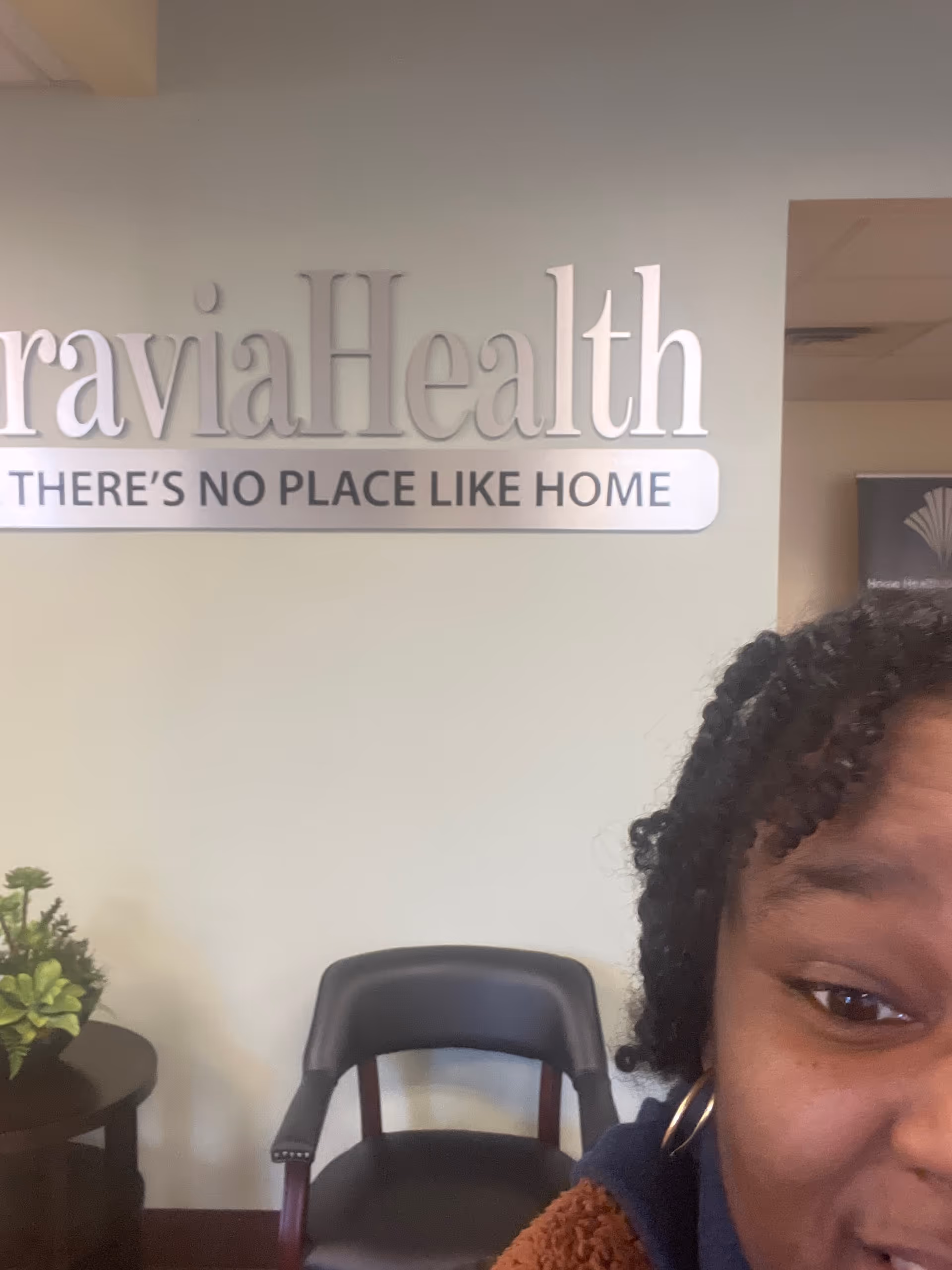 Partial person in the foreground near a MoraviaHealth Erie sign in a waiting lobby.