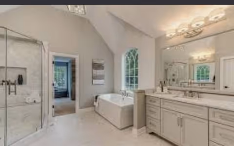 Bright bathroom with tub, walk-in shower, double vanity, and large mirror.