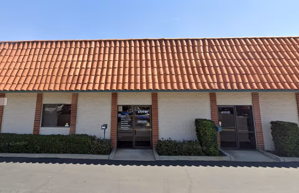 Exterior of a Senior Helpers building with red-tiled roof and glass entrance doors.