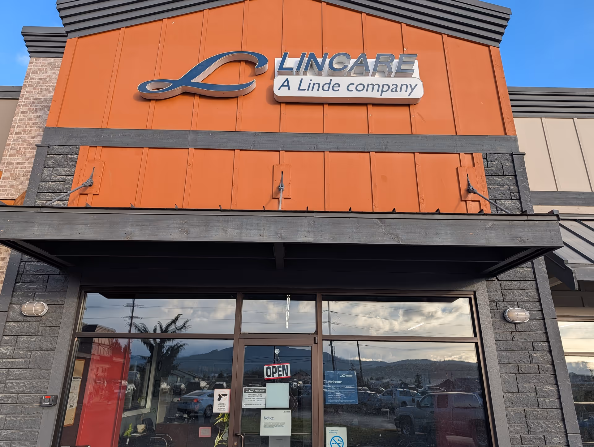 Exterior view of a LinCare facility storefront with large glass doors and an Open sign.