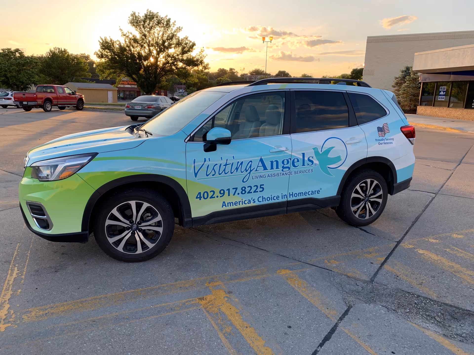 A Visiting Angels service van parked in a lot near a commercial building.