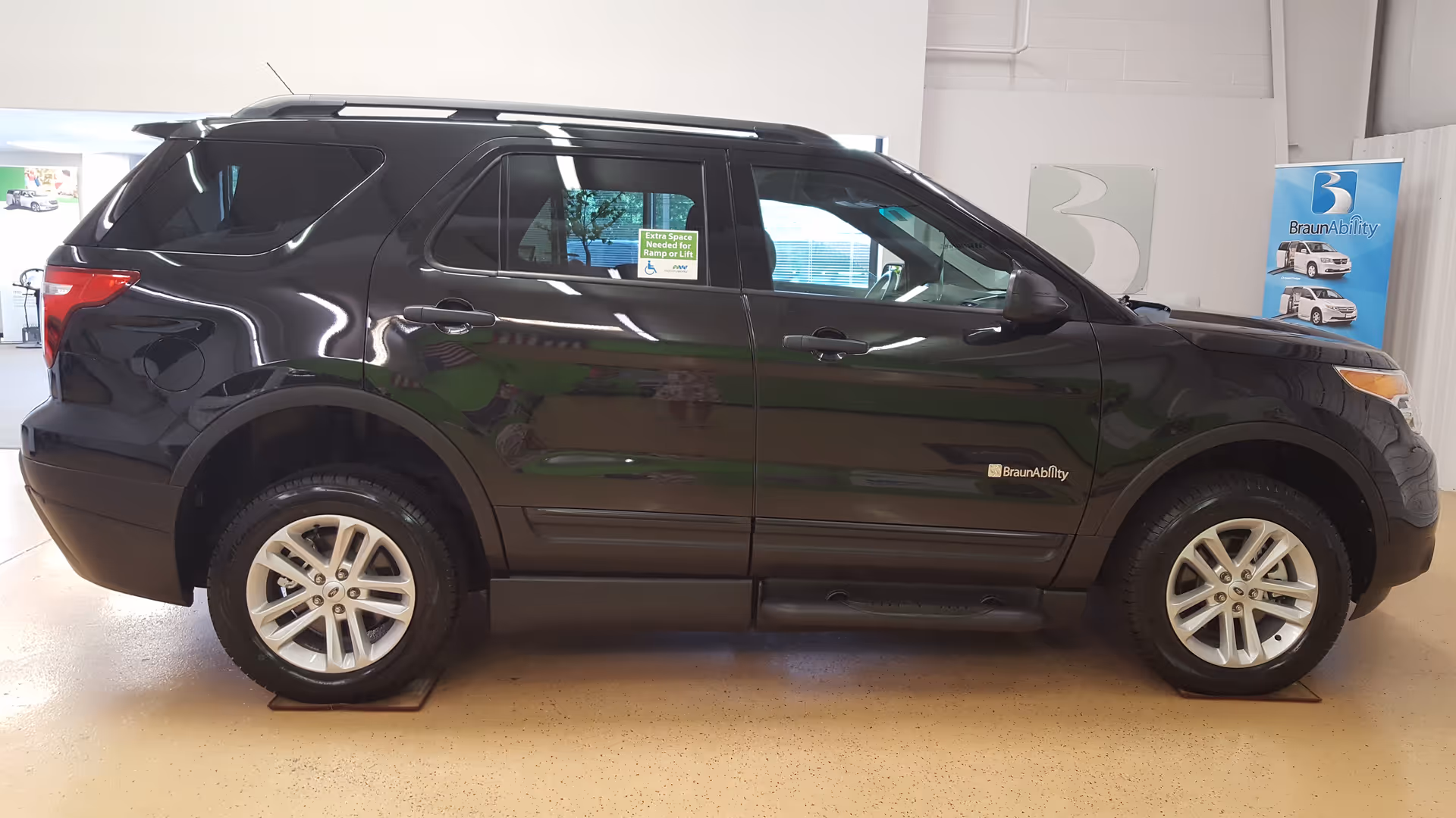 Black SUV on display inside a MobilityWorks showroom with BraunAbility signage.