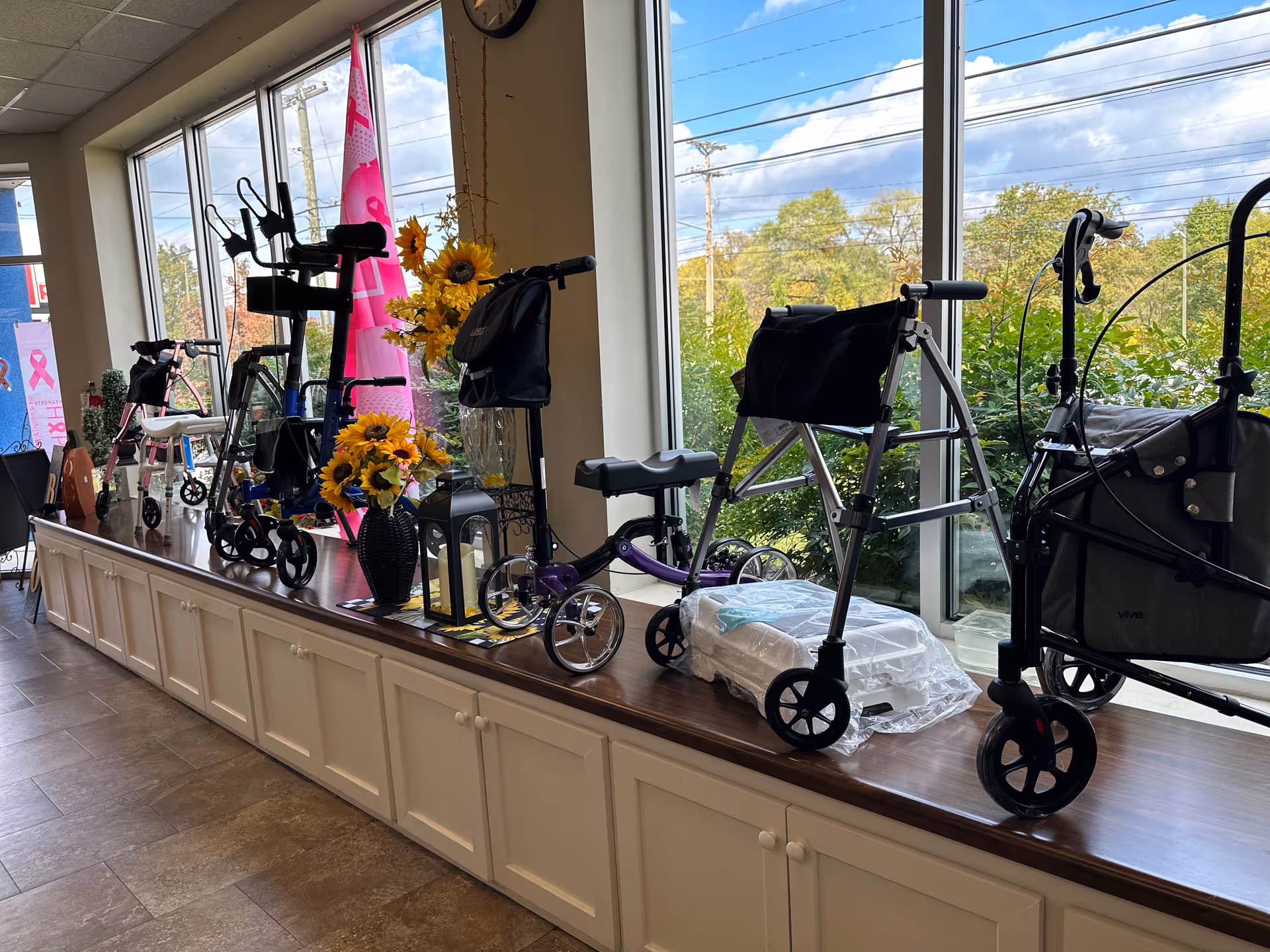 Row of mobility aids and decor on a counter by large windows inside.
