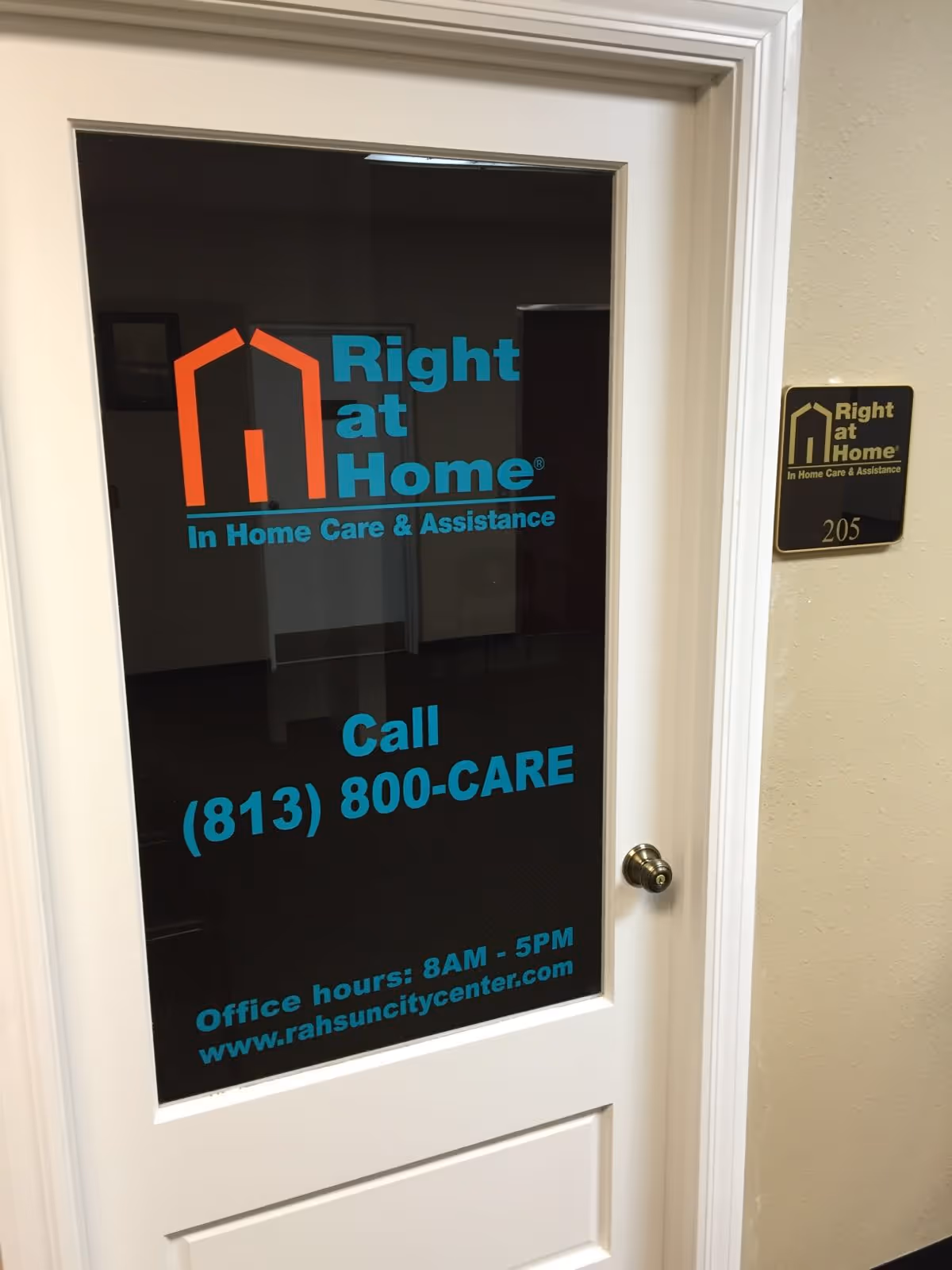 Door with Right at Home logo and contact information in a hallway.
