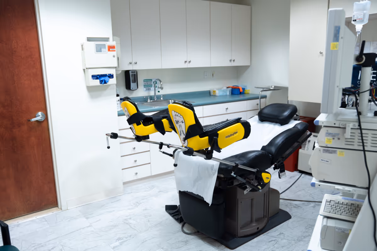 Medical examination chair in a clinical procedure room with cabinets.