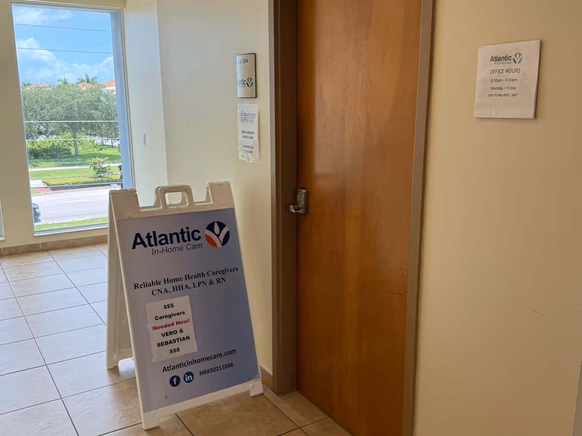 Interior hallway with Atlantic In-Home Care signboard beside a wooden door