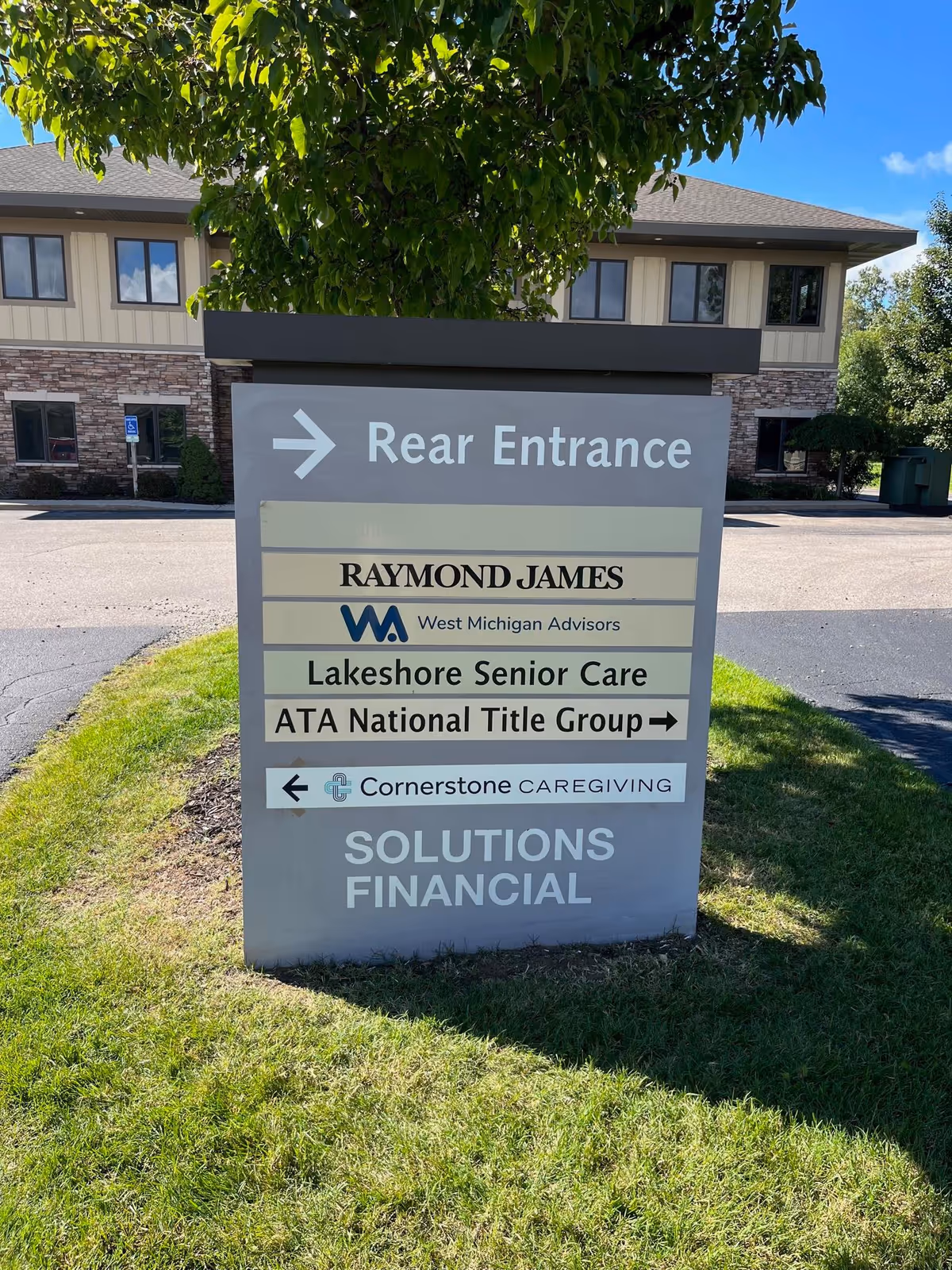 Outdoor sign outside a building displays Rear Entrance and Cornerstone Caregiving branding.