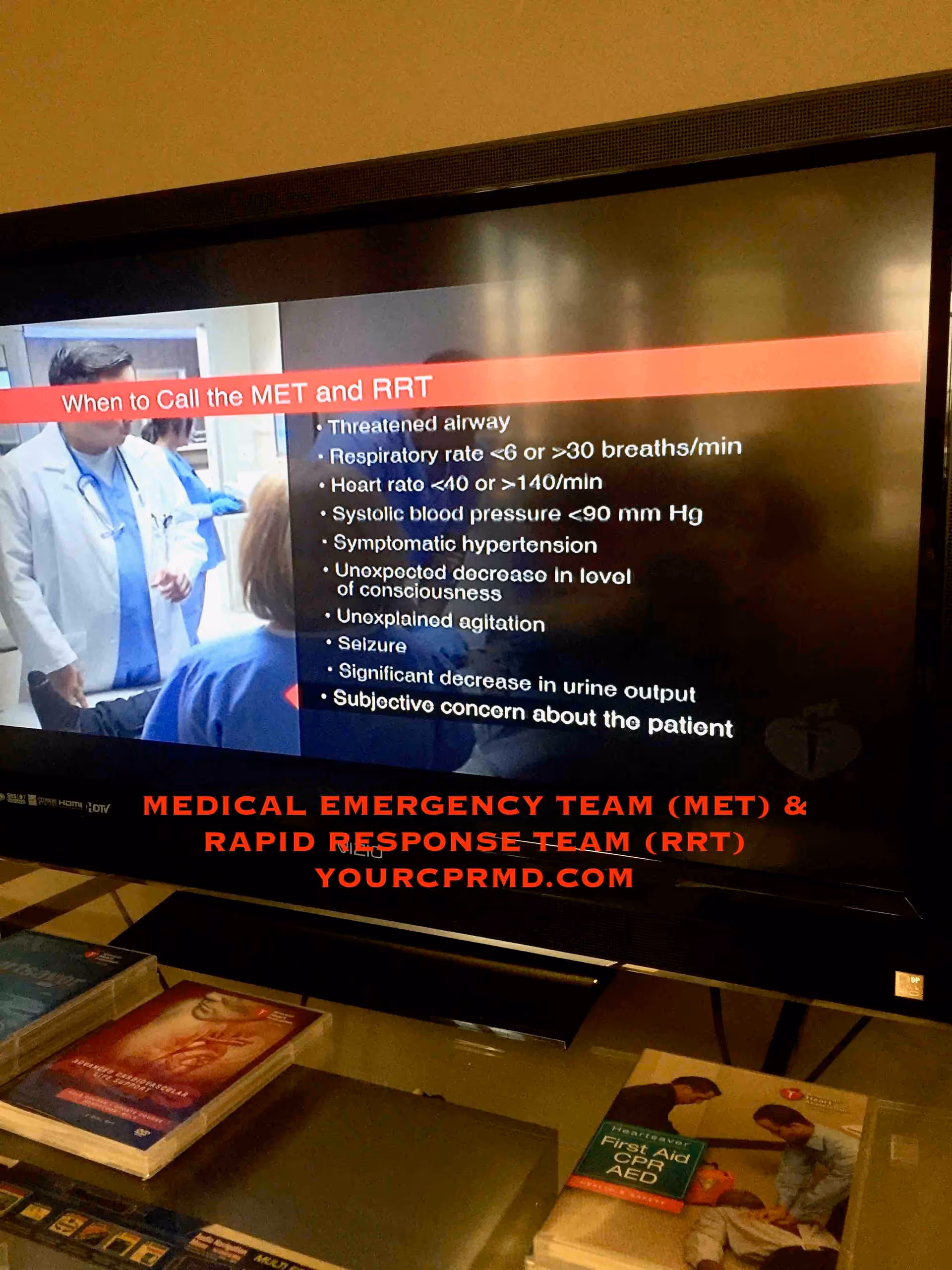 TV screen shows medical emergency slide about MET and RRT during CPR training.