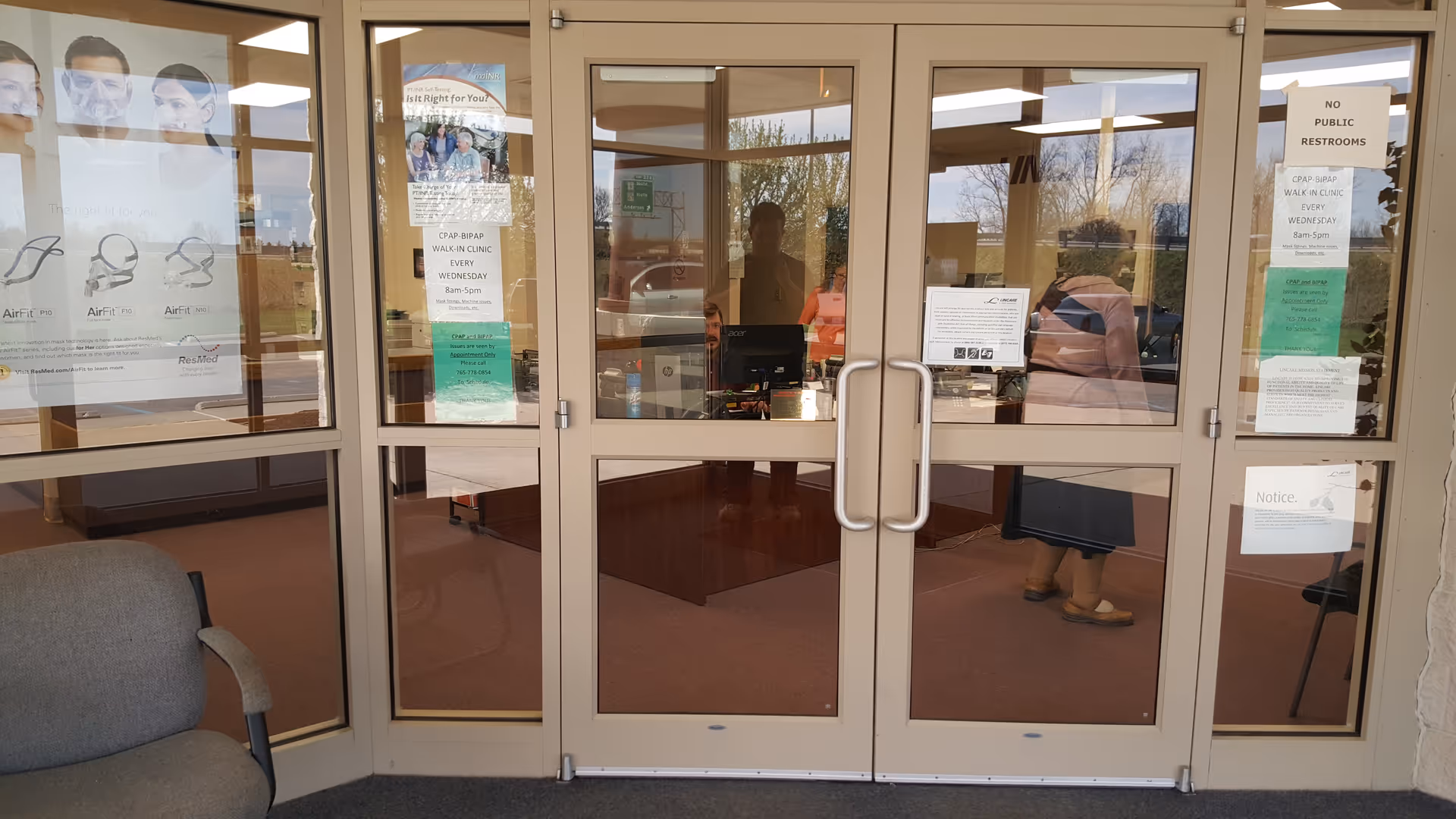 Glass doors open into a lobby with posters and people visible inside