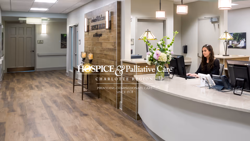 Reception desk with a staff member at a computer in a VIA Health Partners lobby.