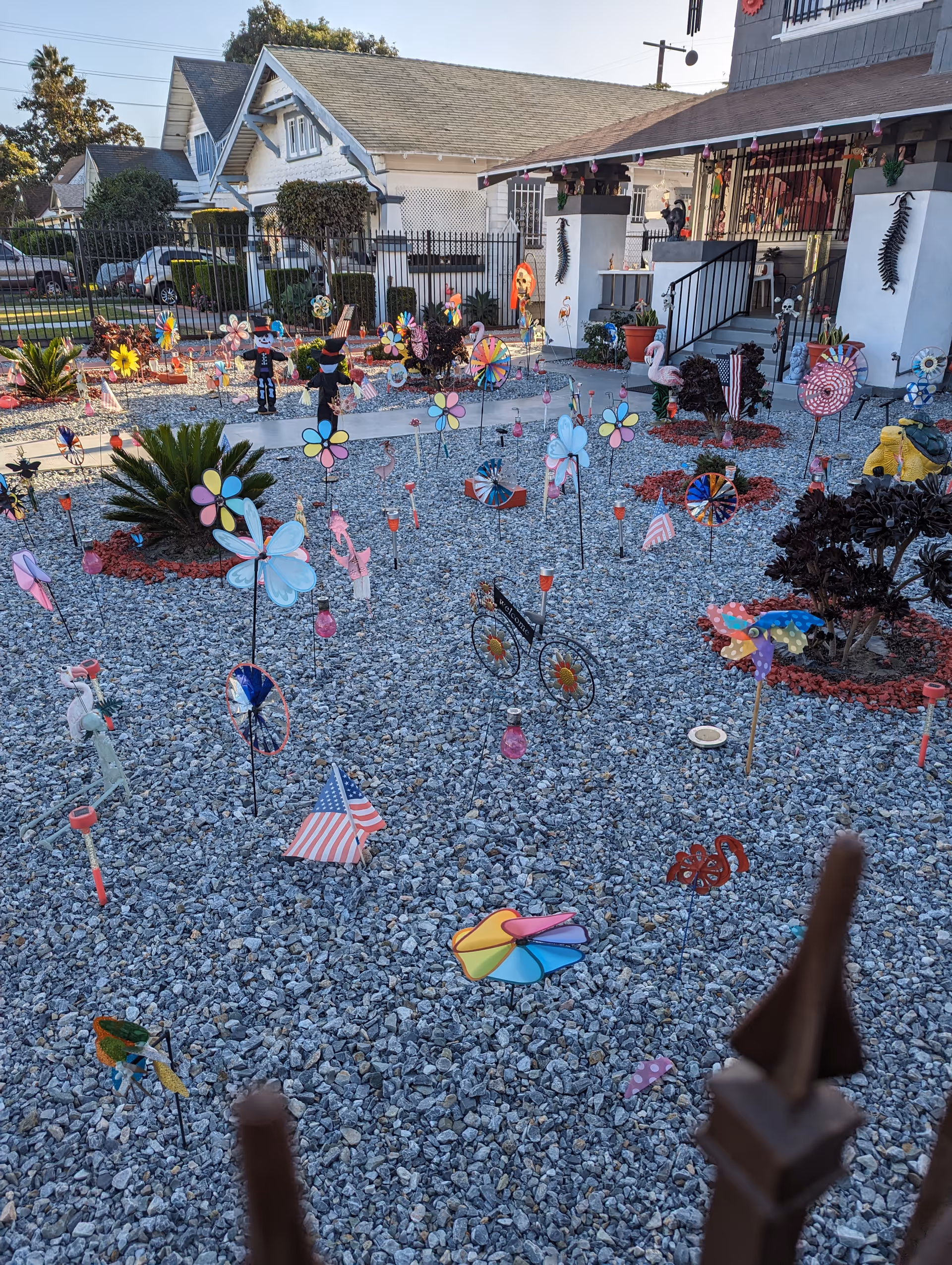 Colorful windmills and garden ornaments dot a gravel exterior yard of a senior care facility.