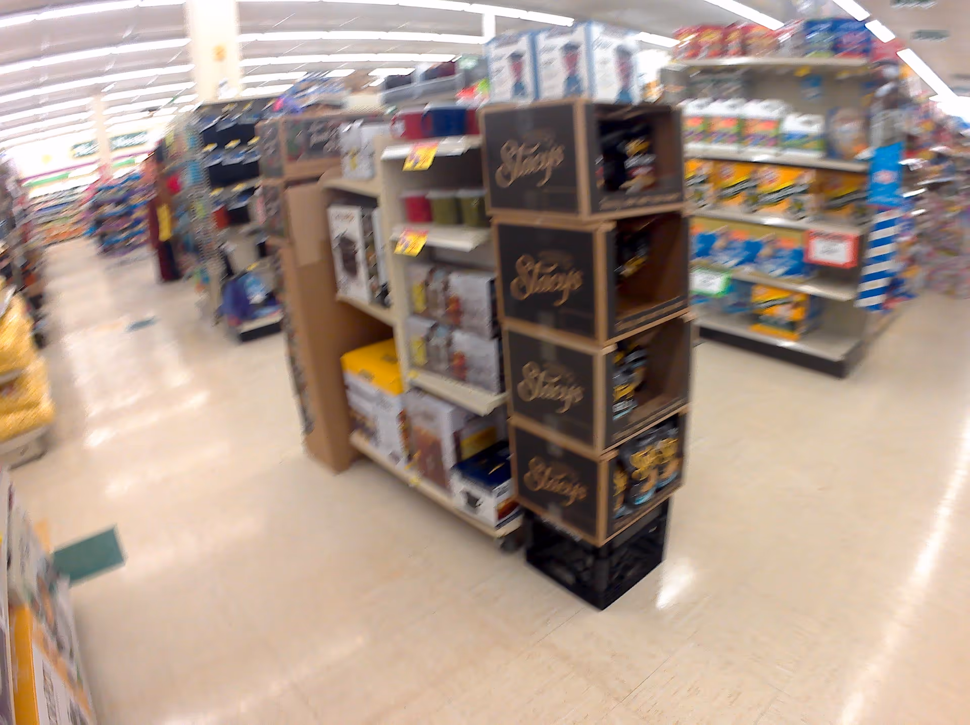 A Discount Drug Mart aisle shows tall shelves with assorted packaged products.