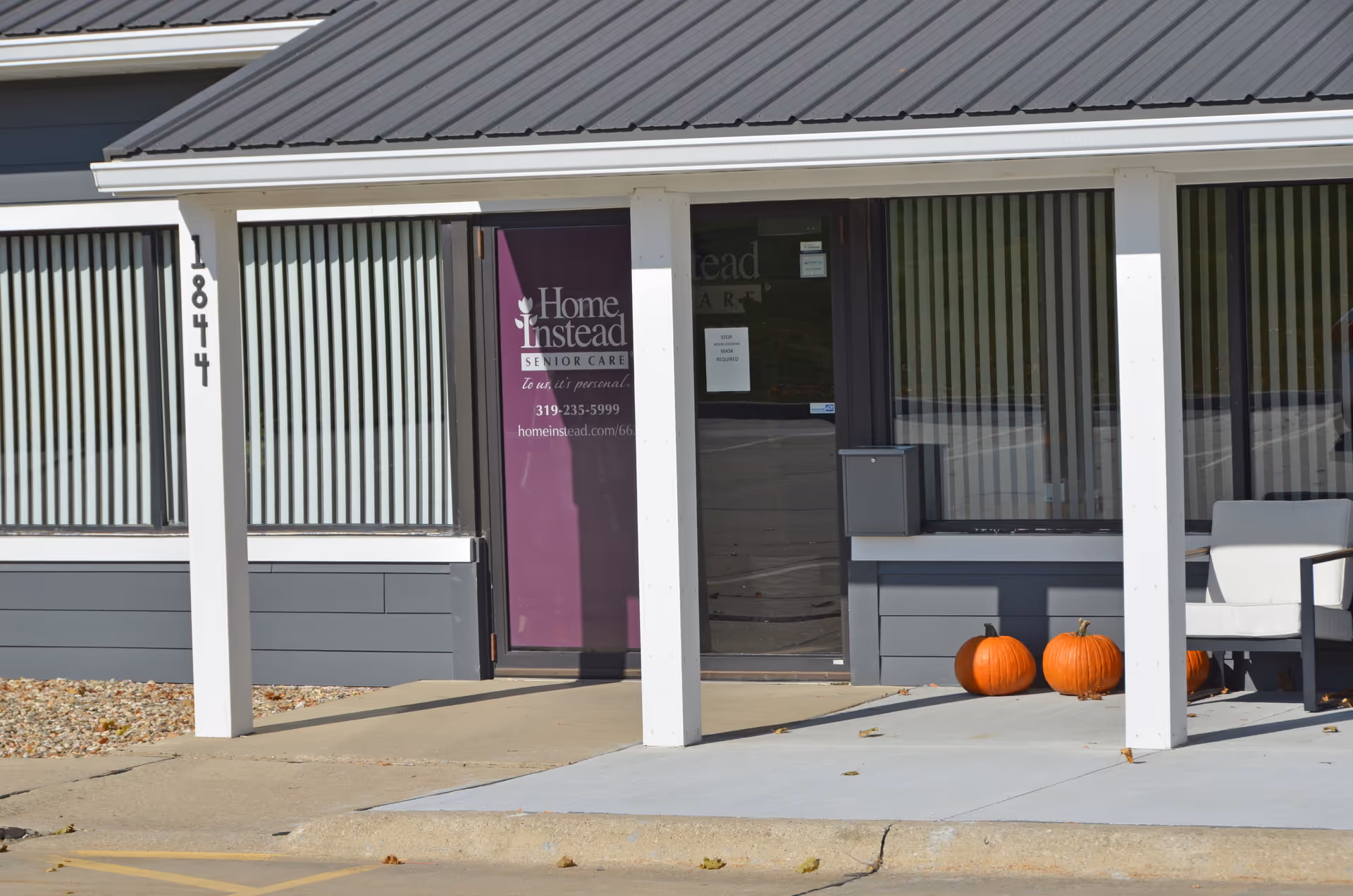 Front exterior of a Home Instead Senior Care building with pumpkins outside