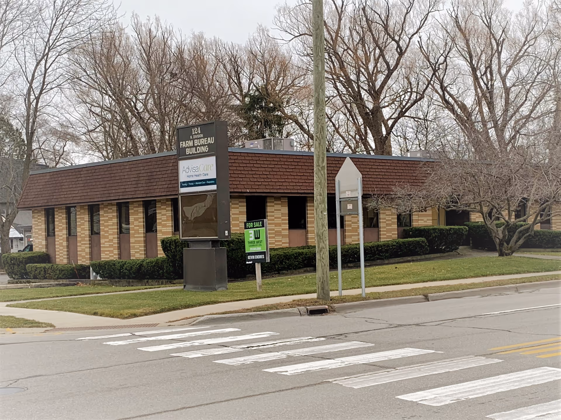 Exterior view of a brick AdvisaCare Home Health & Hospice facility with sign.