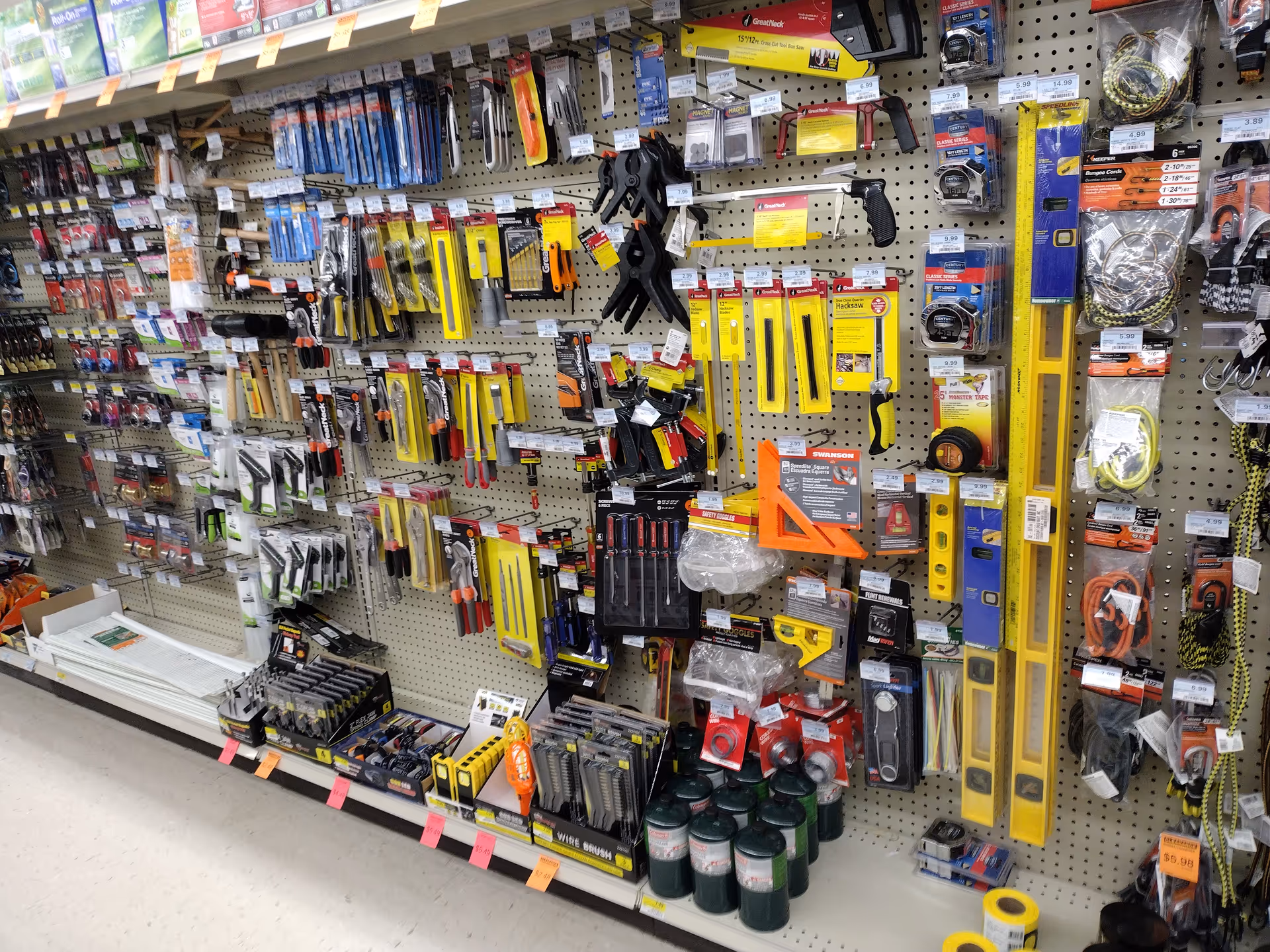 A Discount Drug Mart interior aisle with assorted hardware tools and supplies on pegboard.