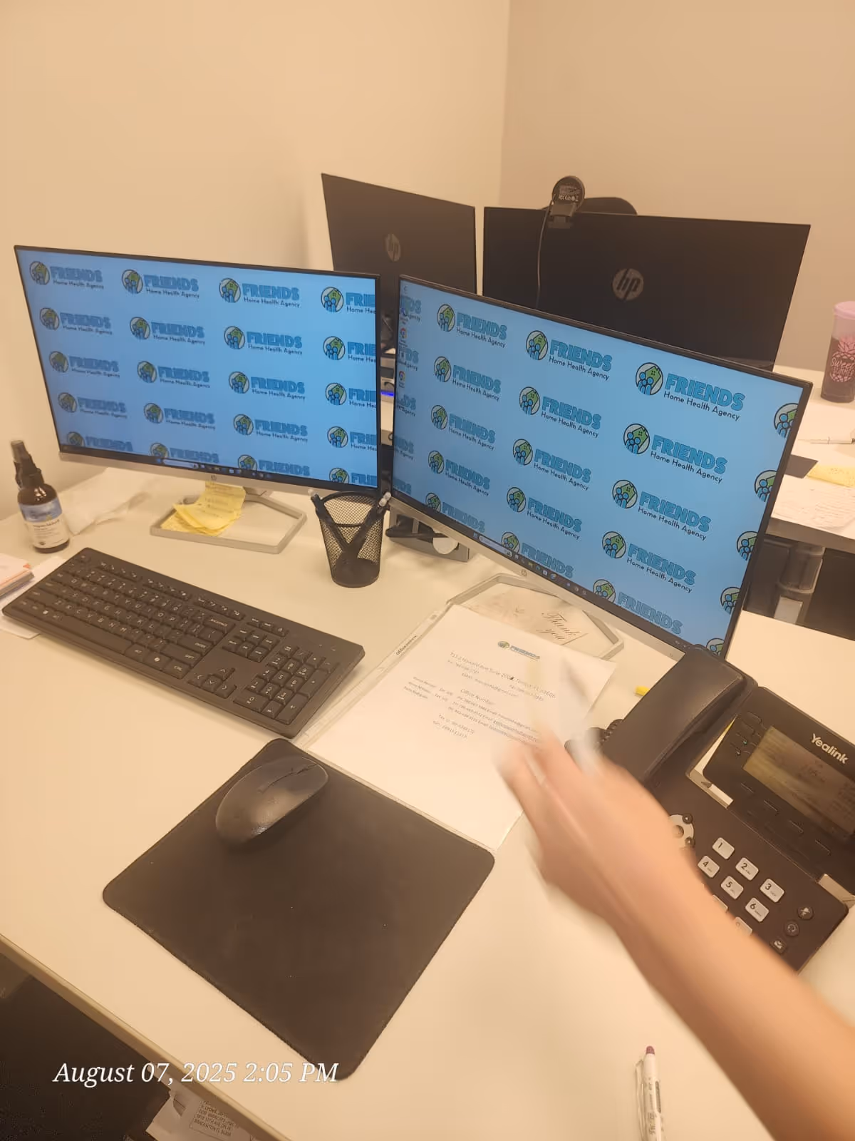 Dual-monitor office desk branded with Friends Home Health Agency logos.