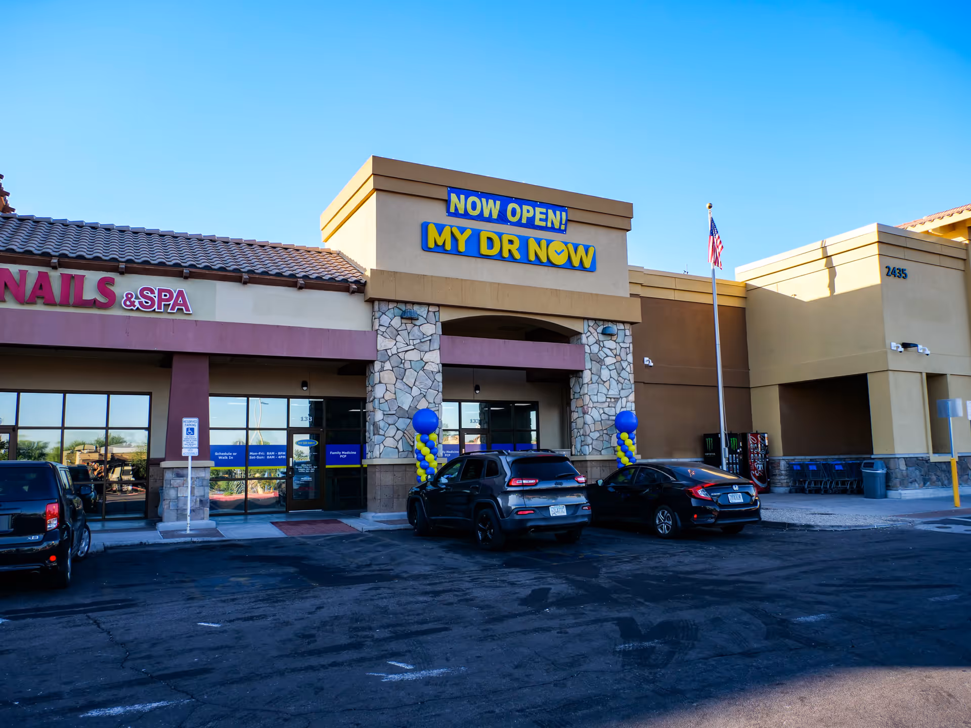 Front of a shopping plaza with a prominent MY DR NOW sign and parked cars.