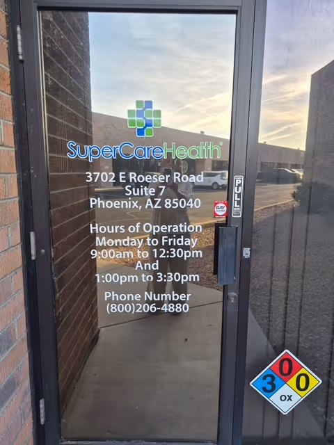 Glass front door with SuperCare Health signage and Phoenix address.