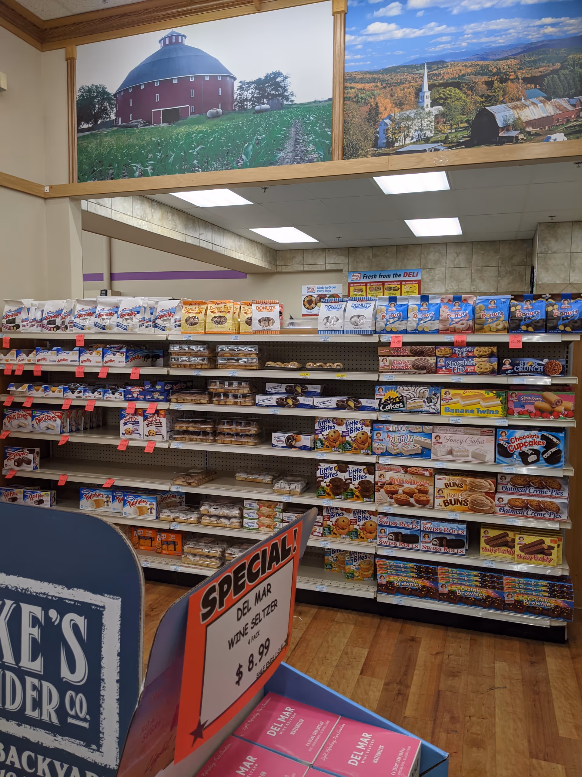 Inside a Discount Drug Mart store, shelves stocked with snacks and signage.