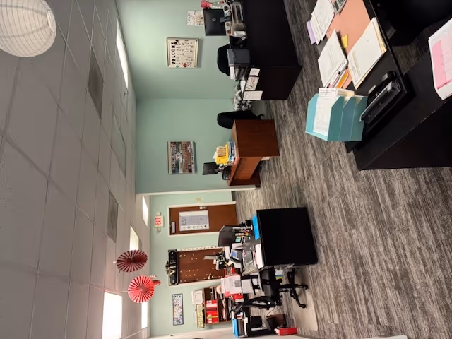 Administrative office area with desks, chairs, computers, and paperwork in a BAYADA facility.