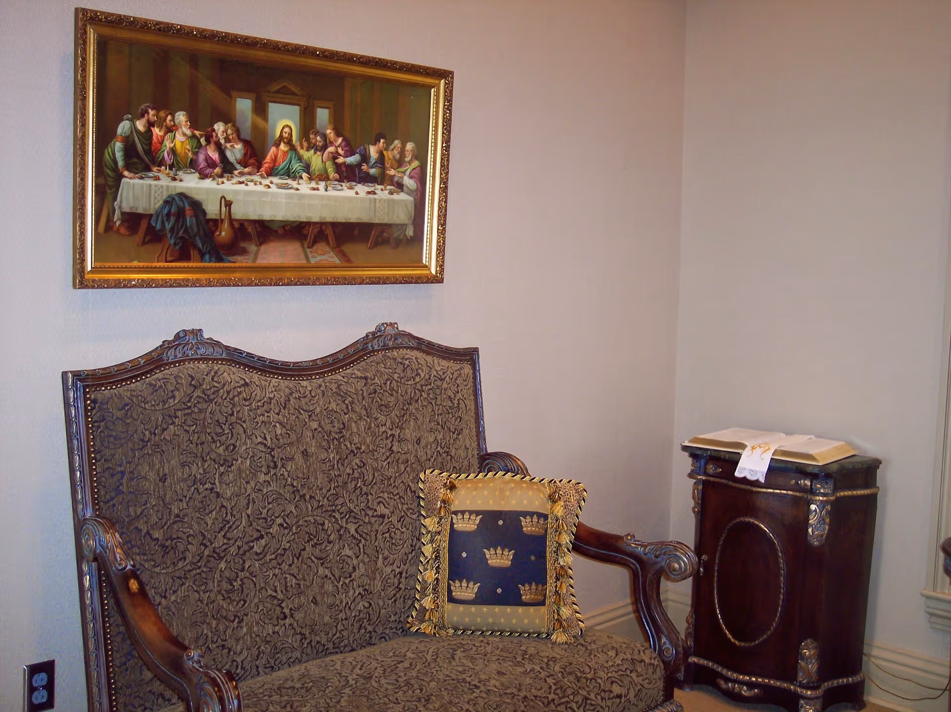Elegant living room corner with ornate patterned sofa, framed painting, and a side cabinet.