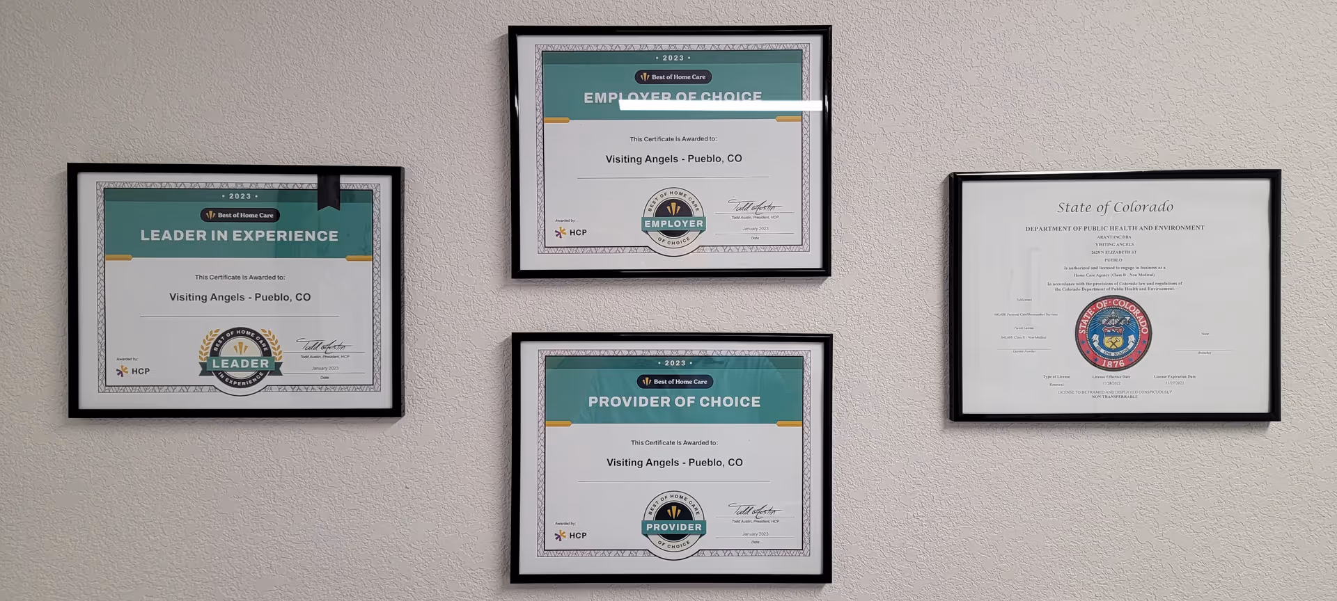 Framed certificates hang on a beige wall inside a Visiting Angels senior home care facility.