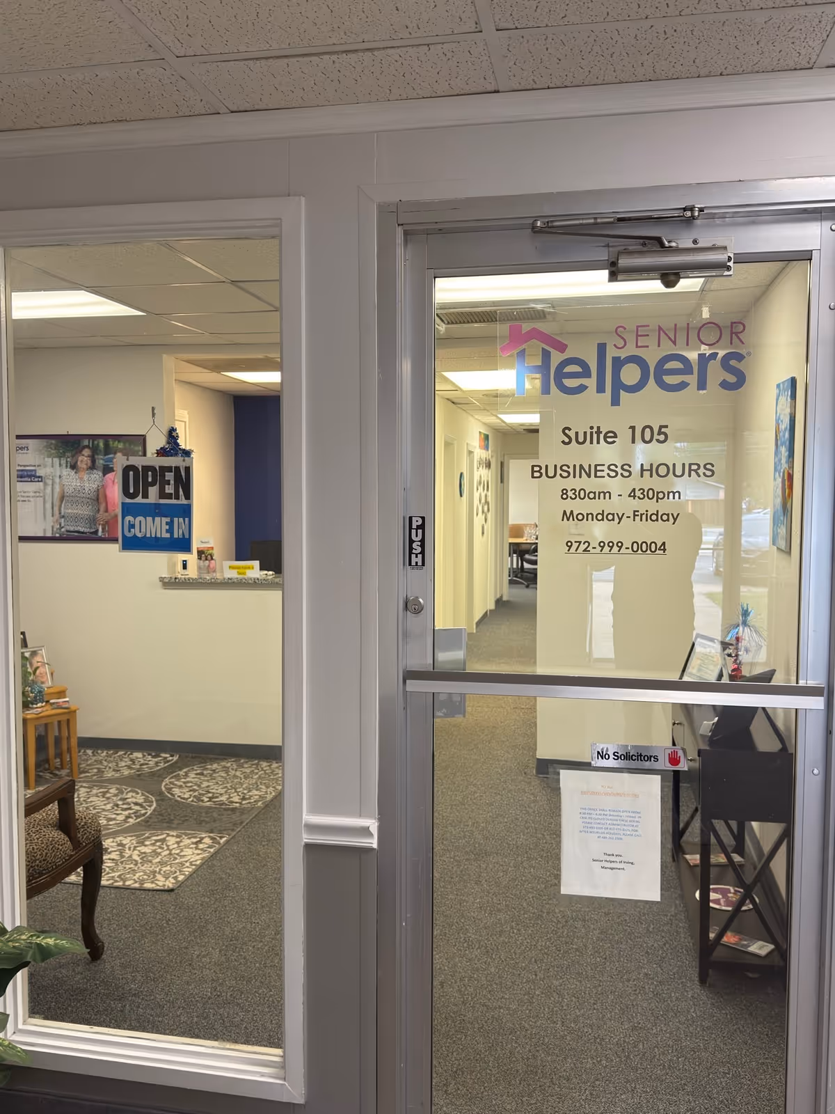 Interior of Senior Helpers office with reception area and glass door displaying Suite 105