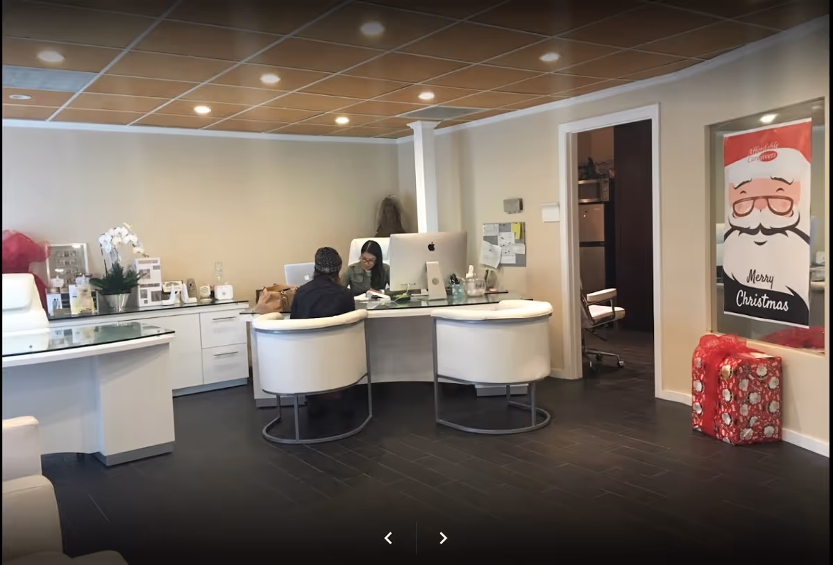 Reception desk in a modern senior living lobby with staff assisting residents.