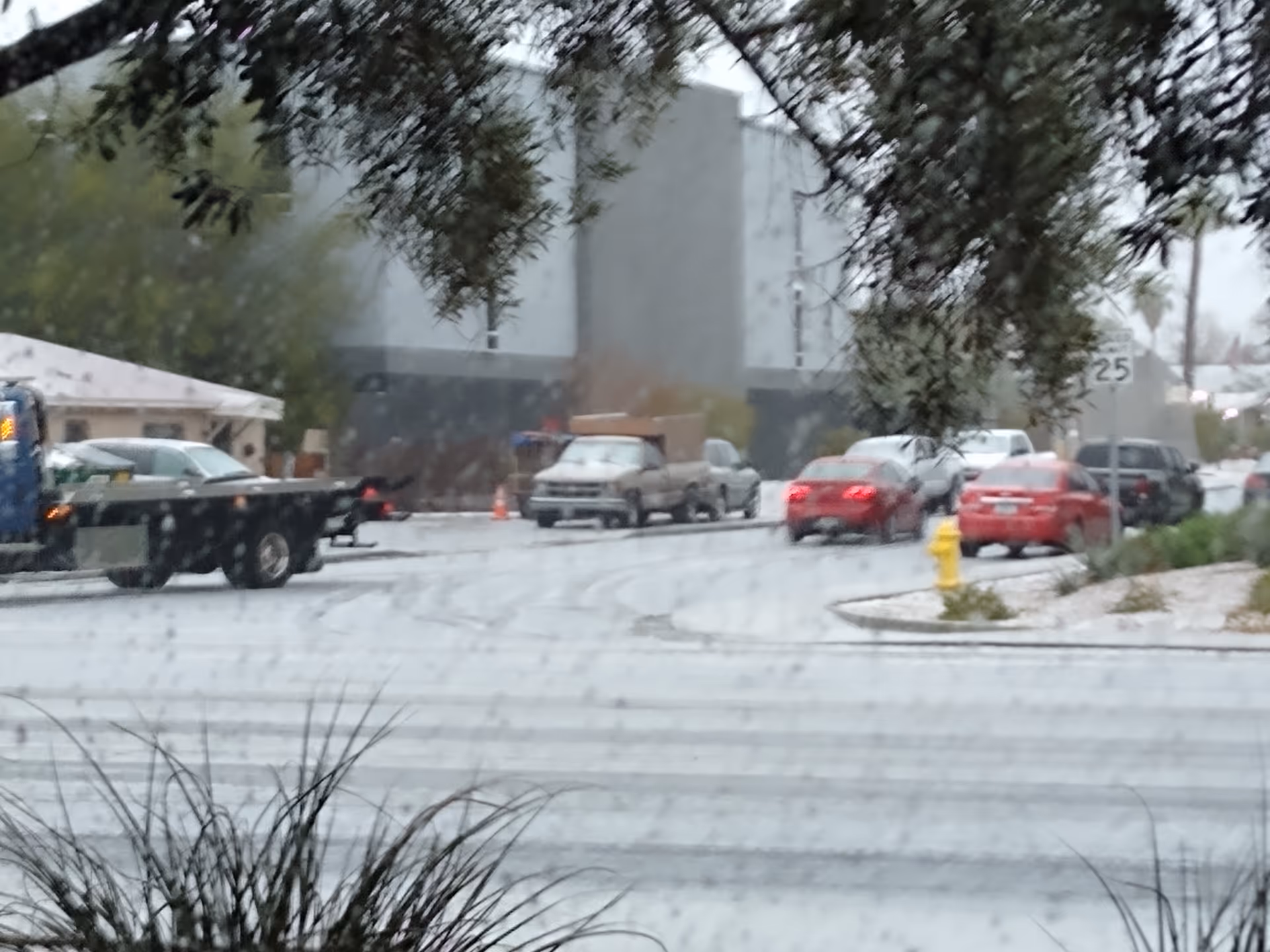 Exterior street scene outside Hospice of the Valley with cars and a building.