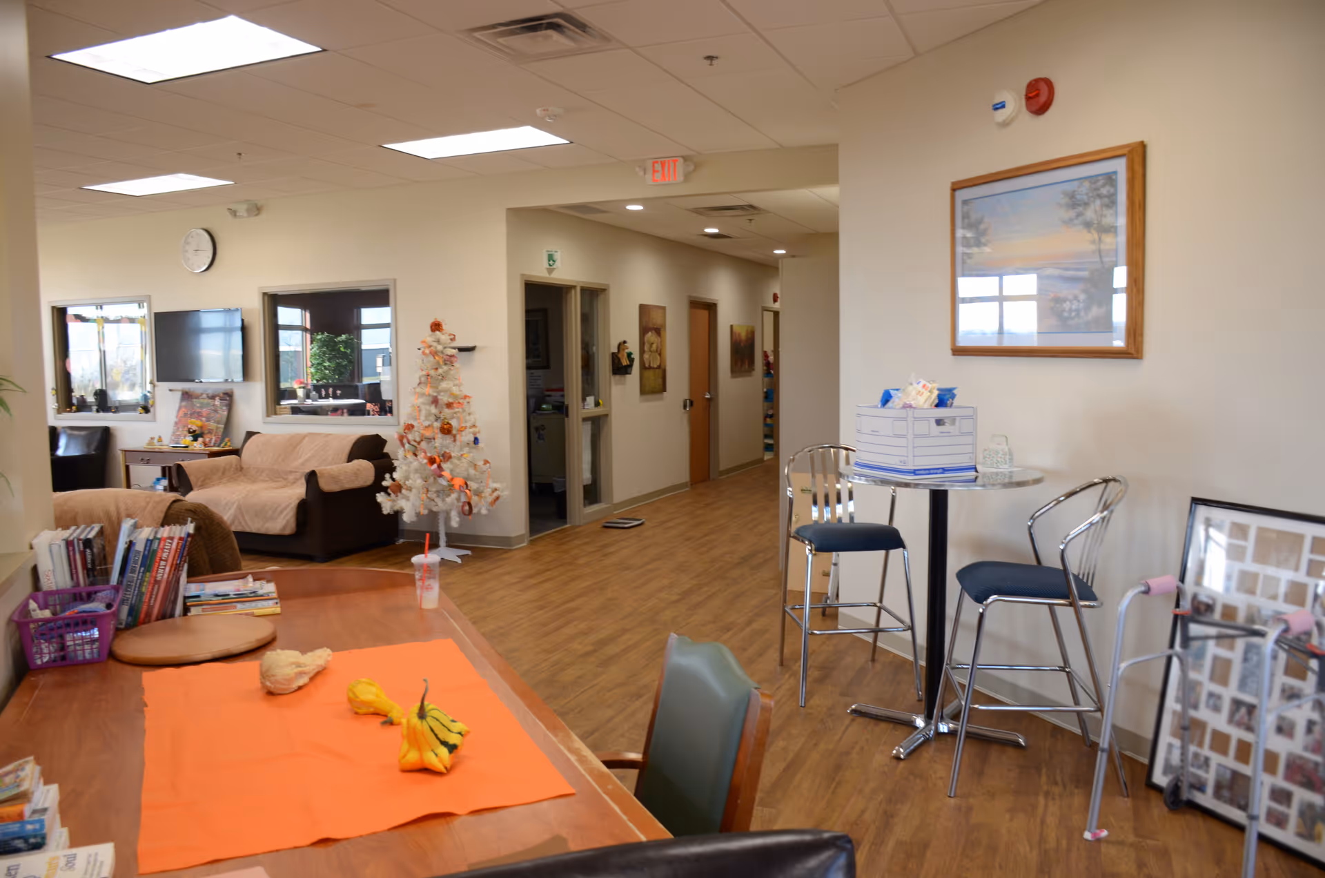 Interior common area with couches, Christmas tree, and holiday crafts table at a senior center.