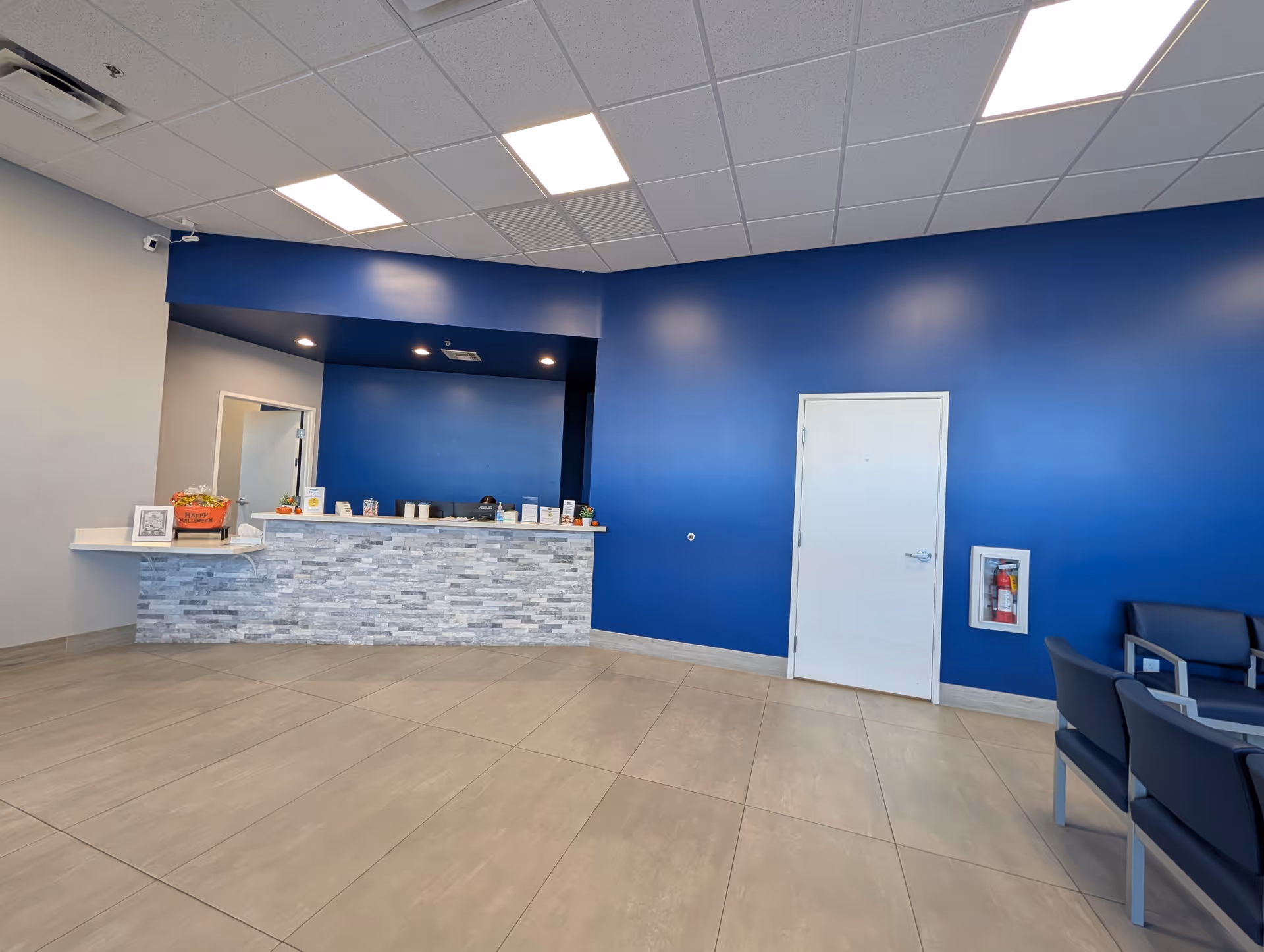 Lobby reception area with blue walls, stone counter, and seating.