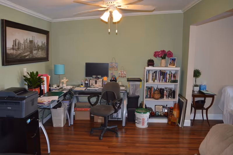 Interior office at Big Heart Home Care featuring a desk, computer, and bookshelf.