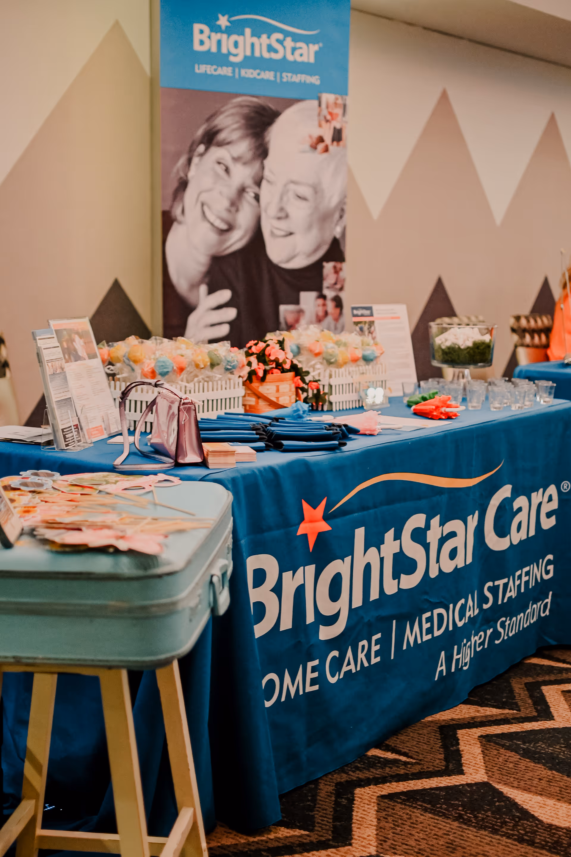 Blue BrightStar Care promotional table with banners and materials at an indoor event.