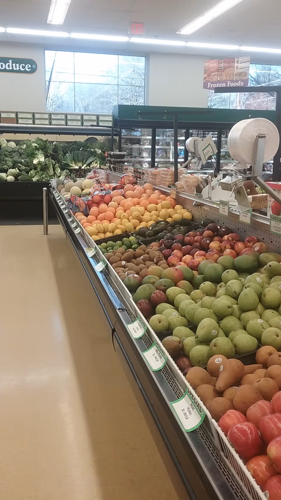 Interior view of a grocery store produce section with stacks of fruit.
