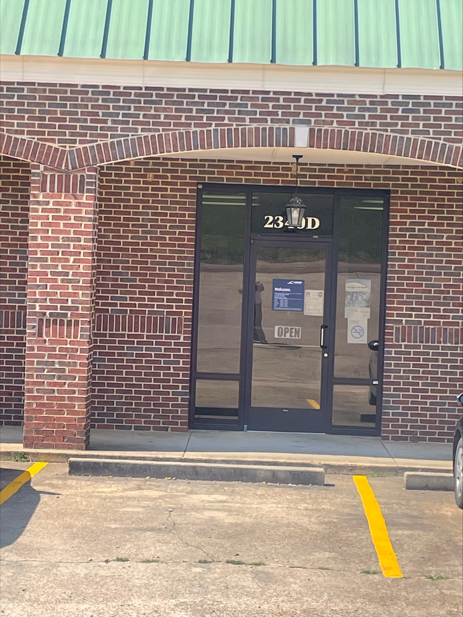 Brick exterior with glass double doors, arched brickwork, and an open sign at the entrance.