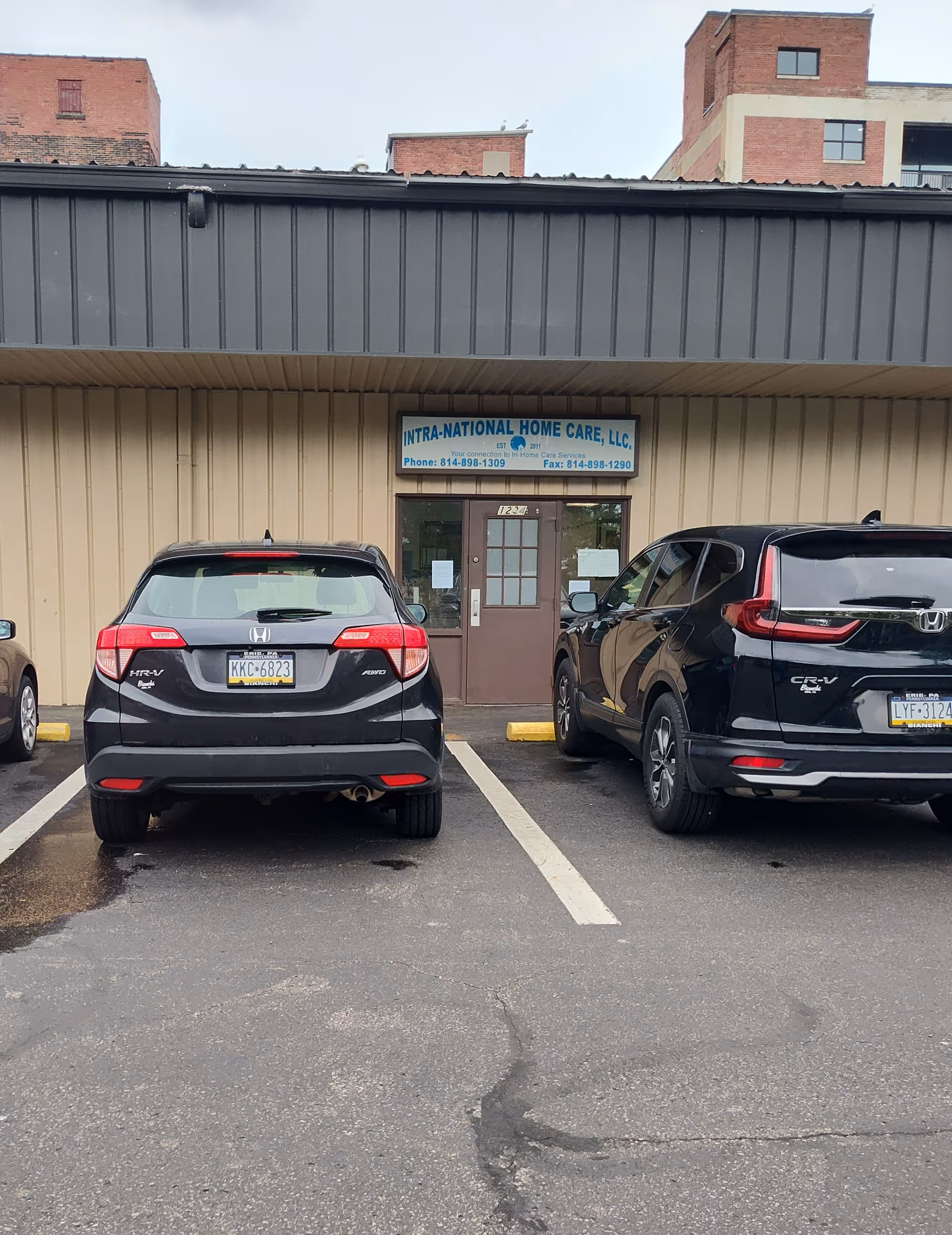 Front facade of INTRA-NATIONAL HOME CARE, LLC, with parked cars in a lot.