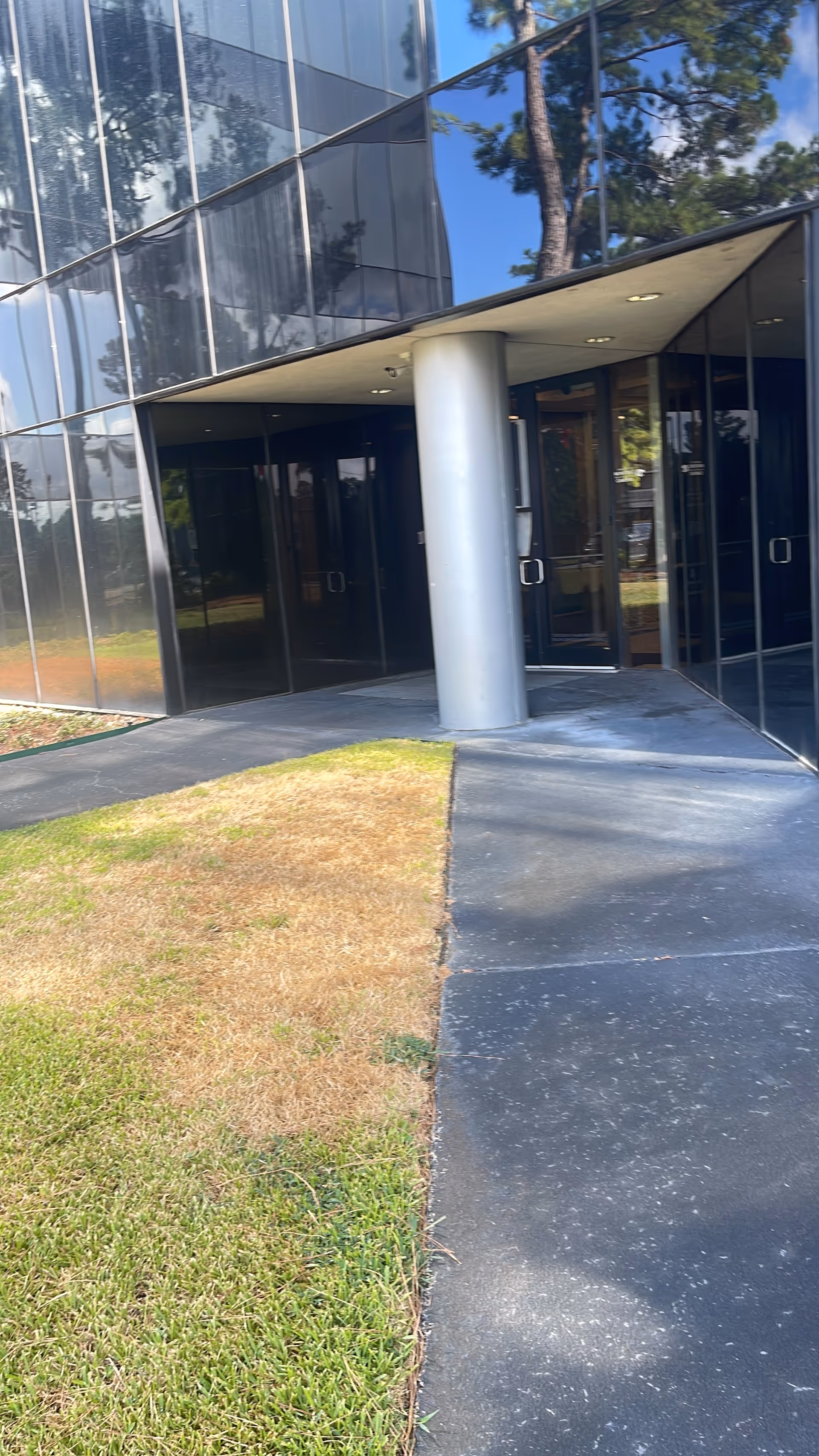 Gentiva Hospice building entrance with glass facade, doors, and a round column.