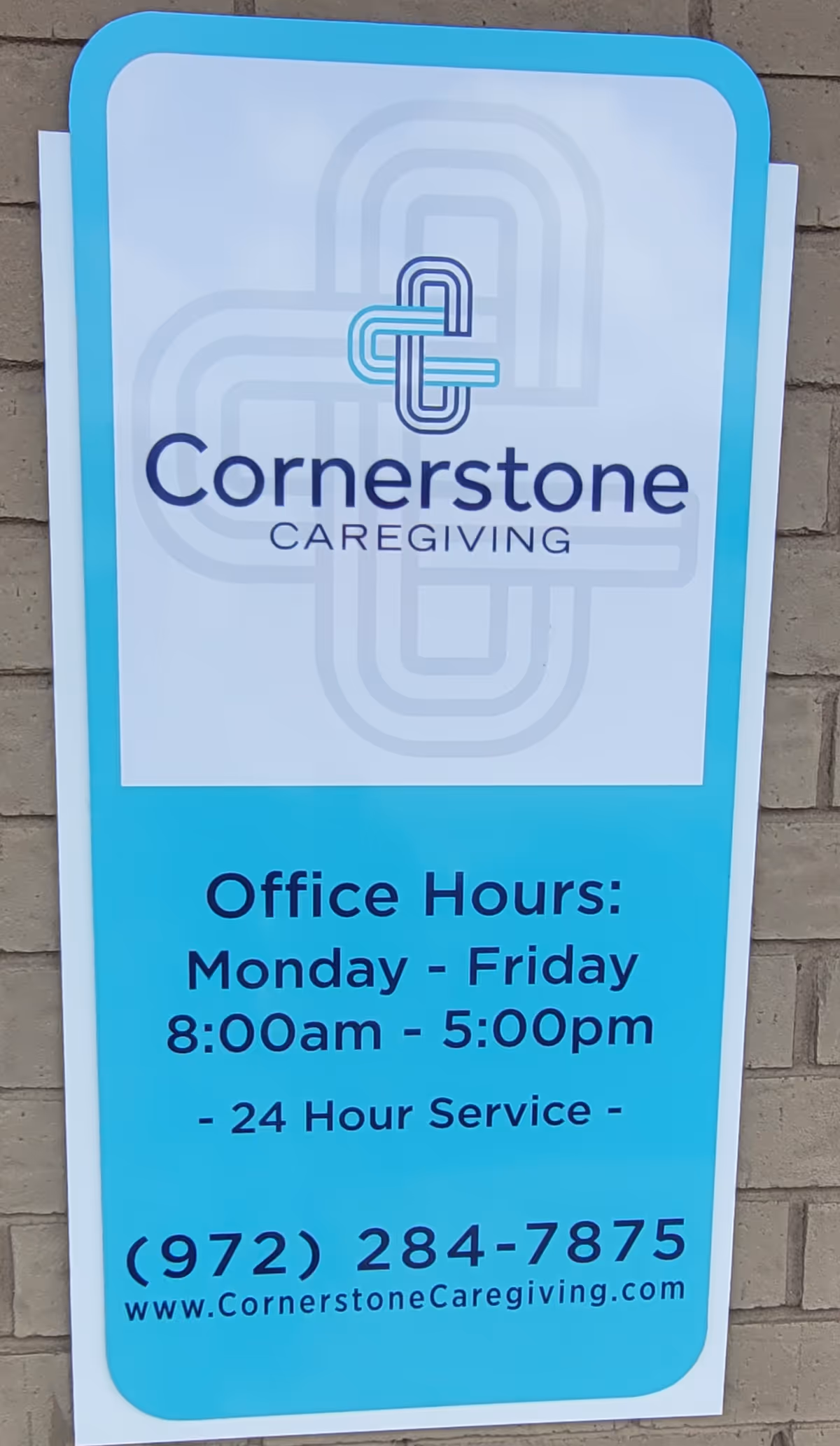 Cornerstone Caregiving sign on exterior wall displaying office hours and contact information.
