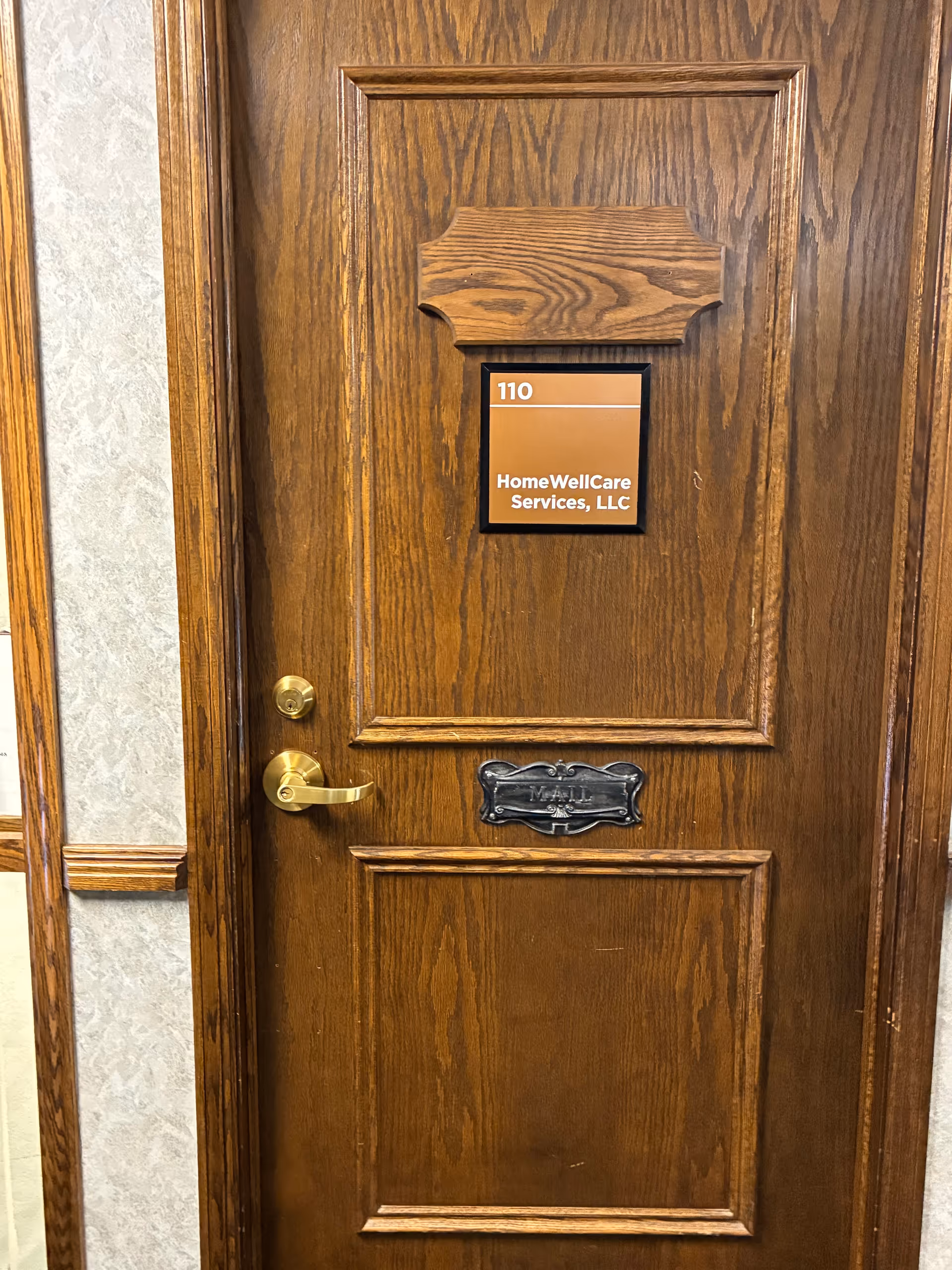 Wooden door with room number 110 and HomeWellCare Services sign.