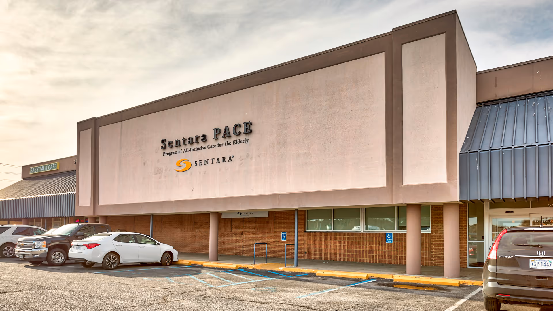 Exterior view of Sentara PACE facility with cars parked in front.