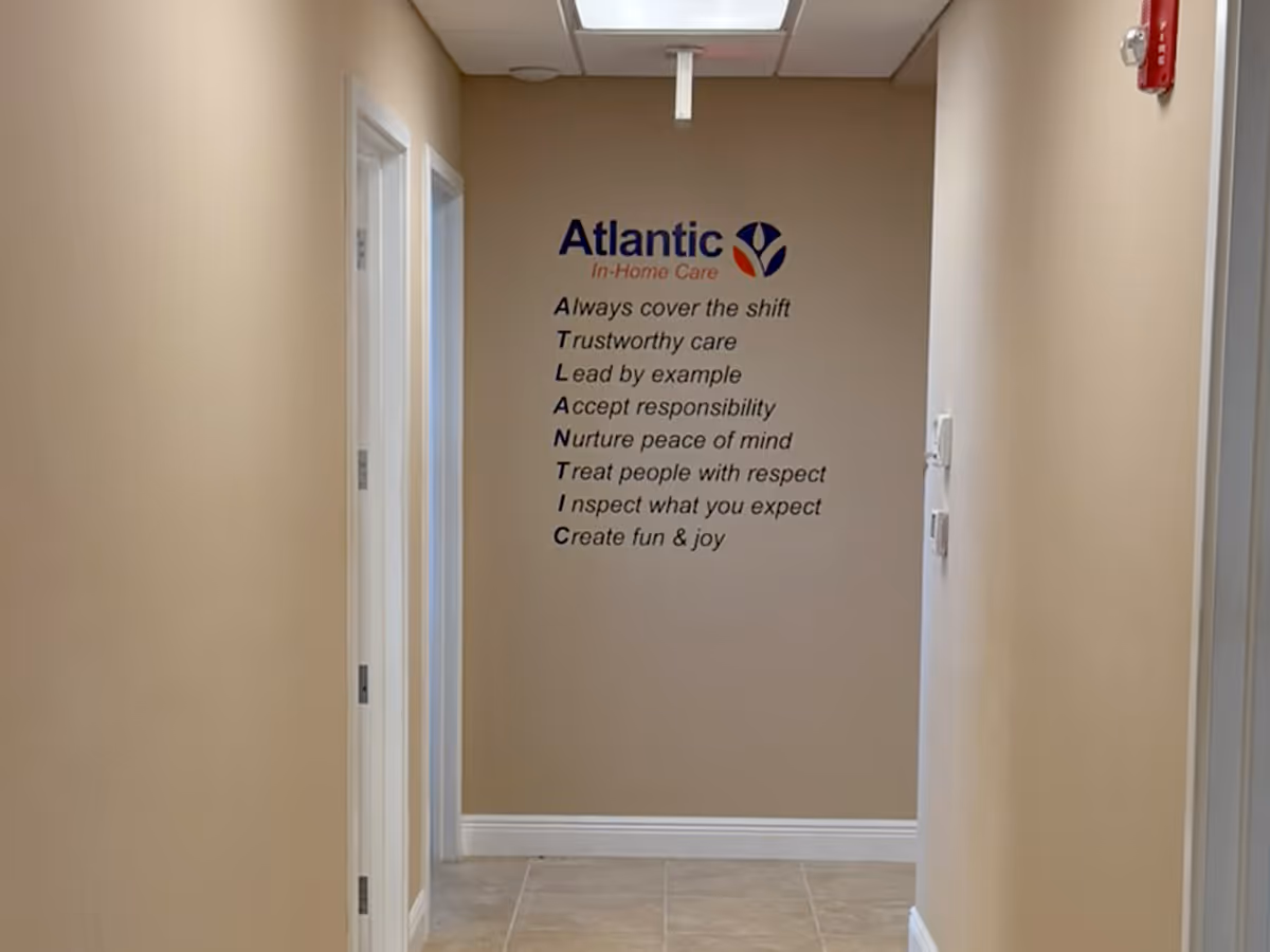 Hallway interior with Atlantic In-Home Care wall logo and motto.