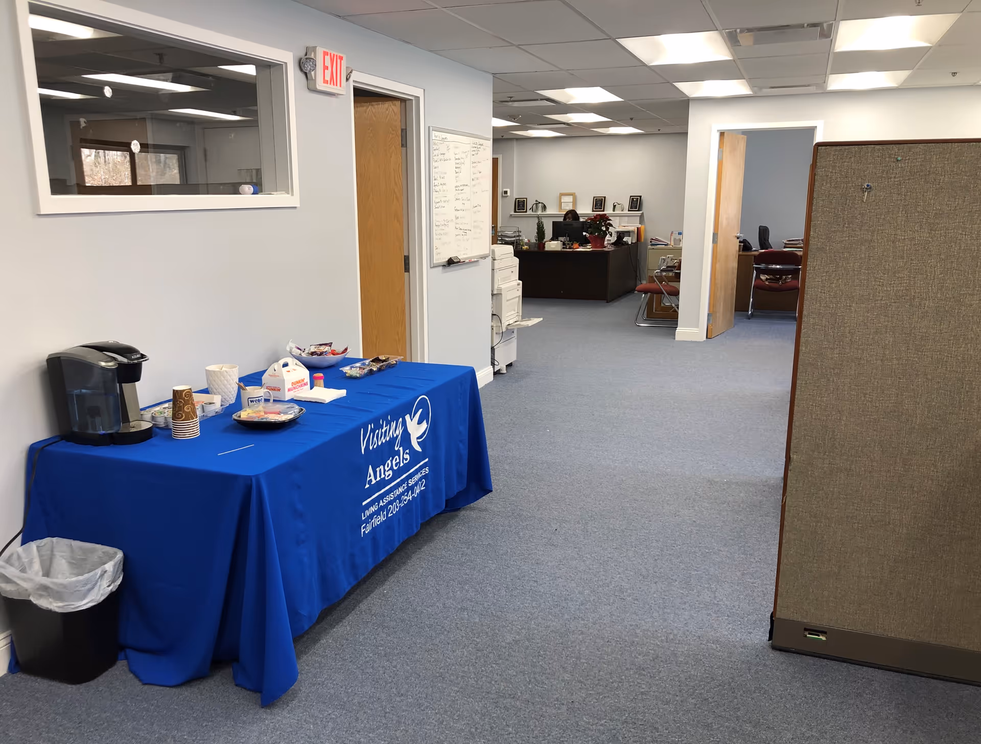 Interior of a Visiting Angels office area with a blue branded refreshment table