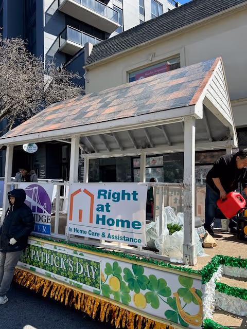 Outdoor parade float for Right at Home with signage and shamrock decorations.