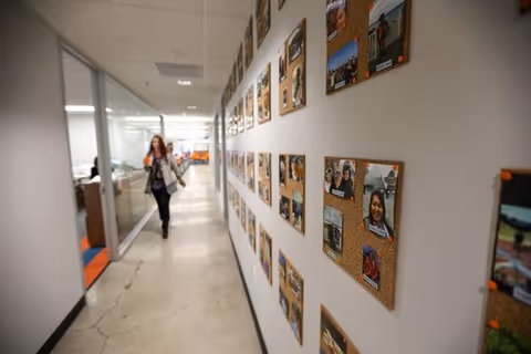 A hallway with photo boards along the wall and a person walking.