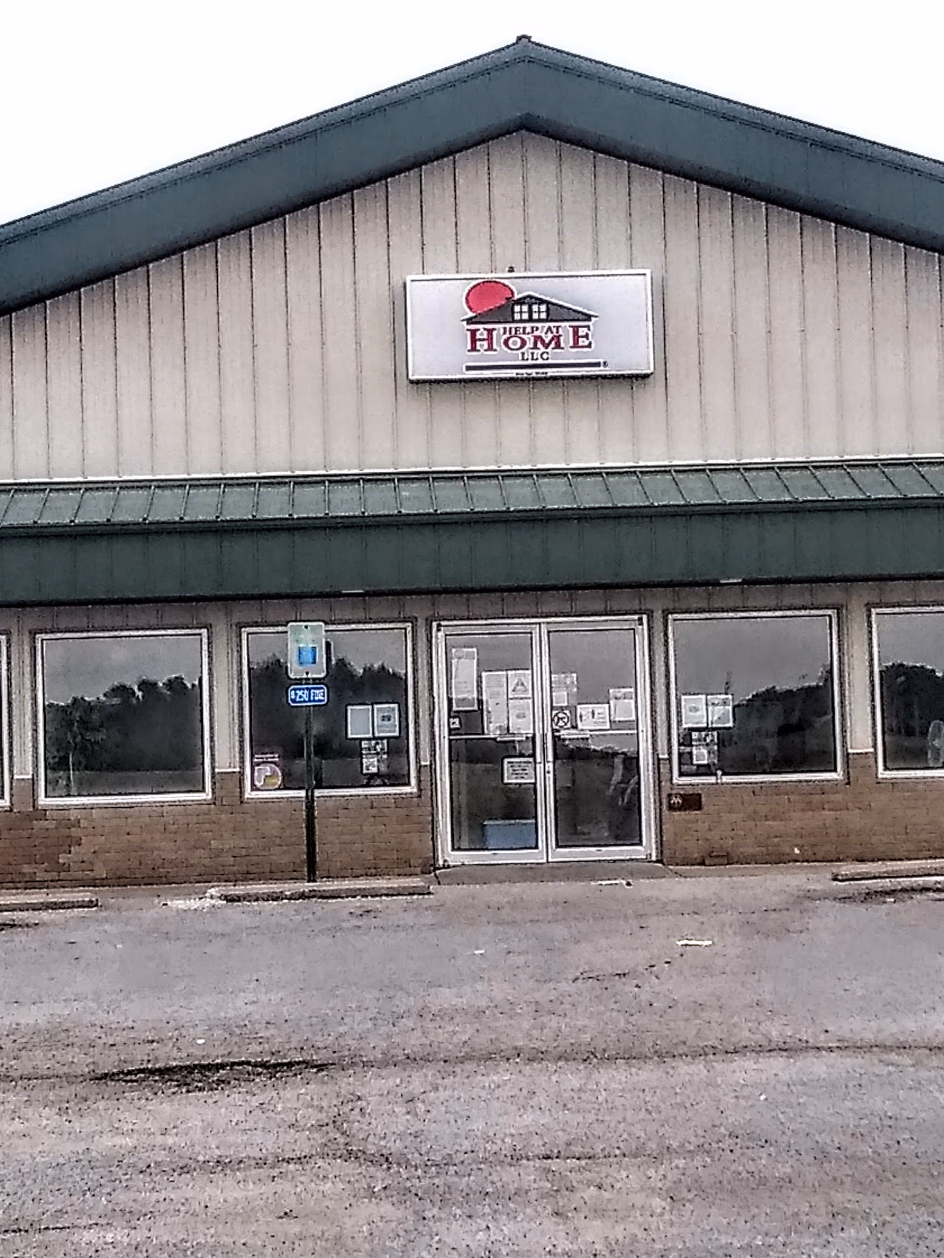 Exterior front of Help at Home facility with entry doors and sign.