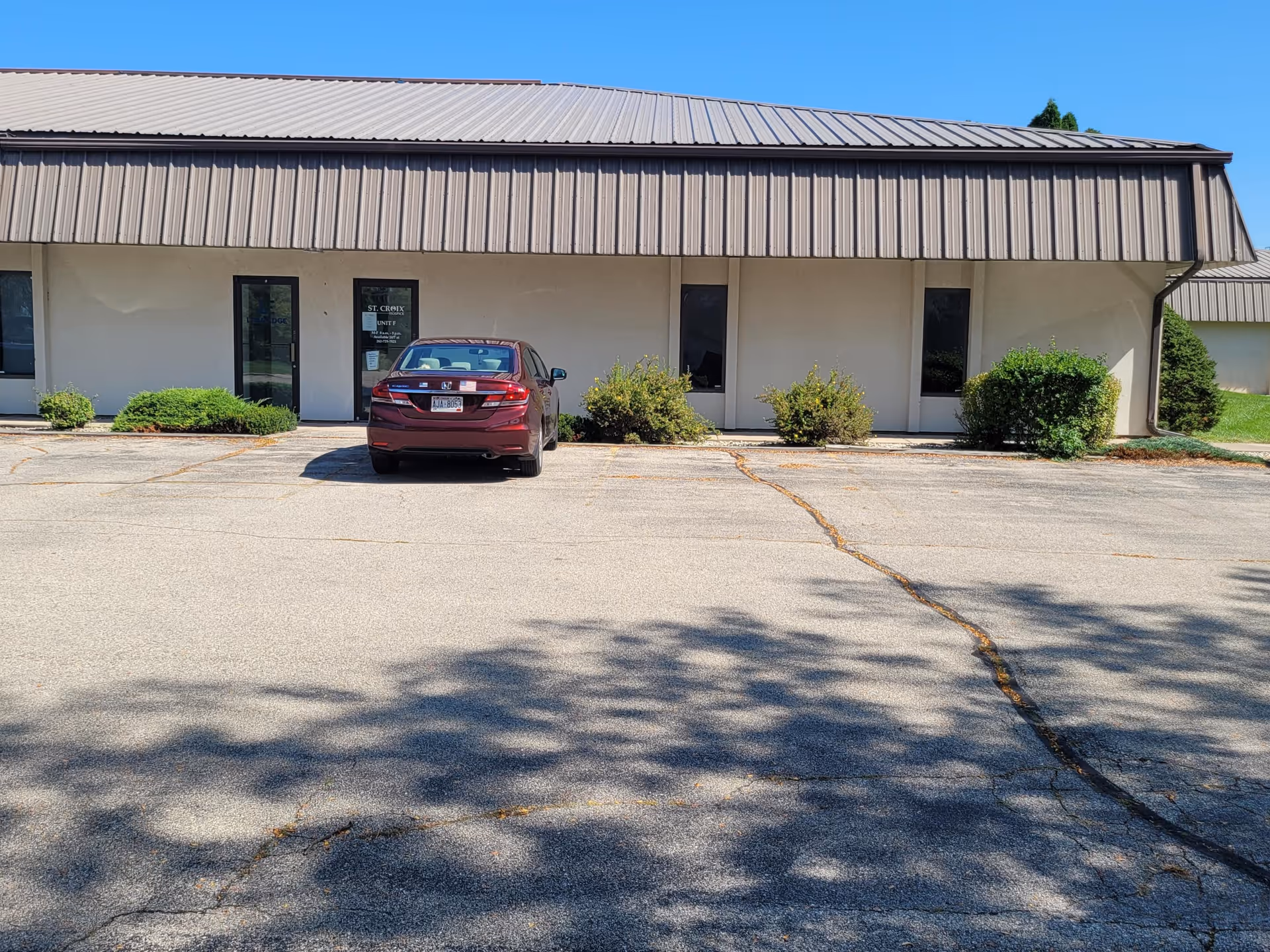 Exterior view of a single-story St. Croix Hospice building with a maroon car parked in front.