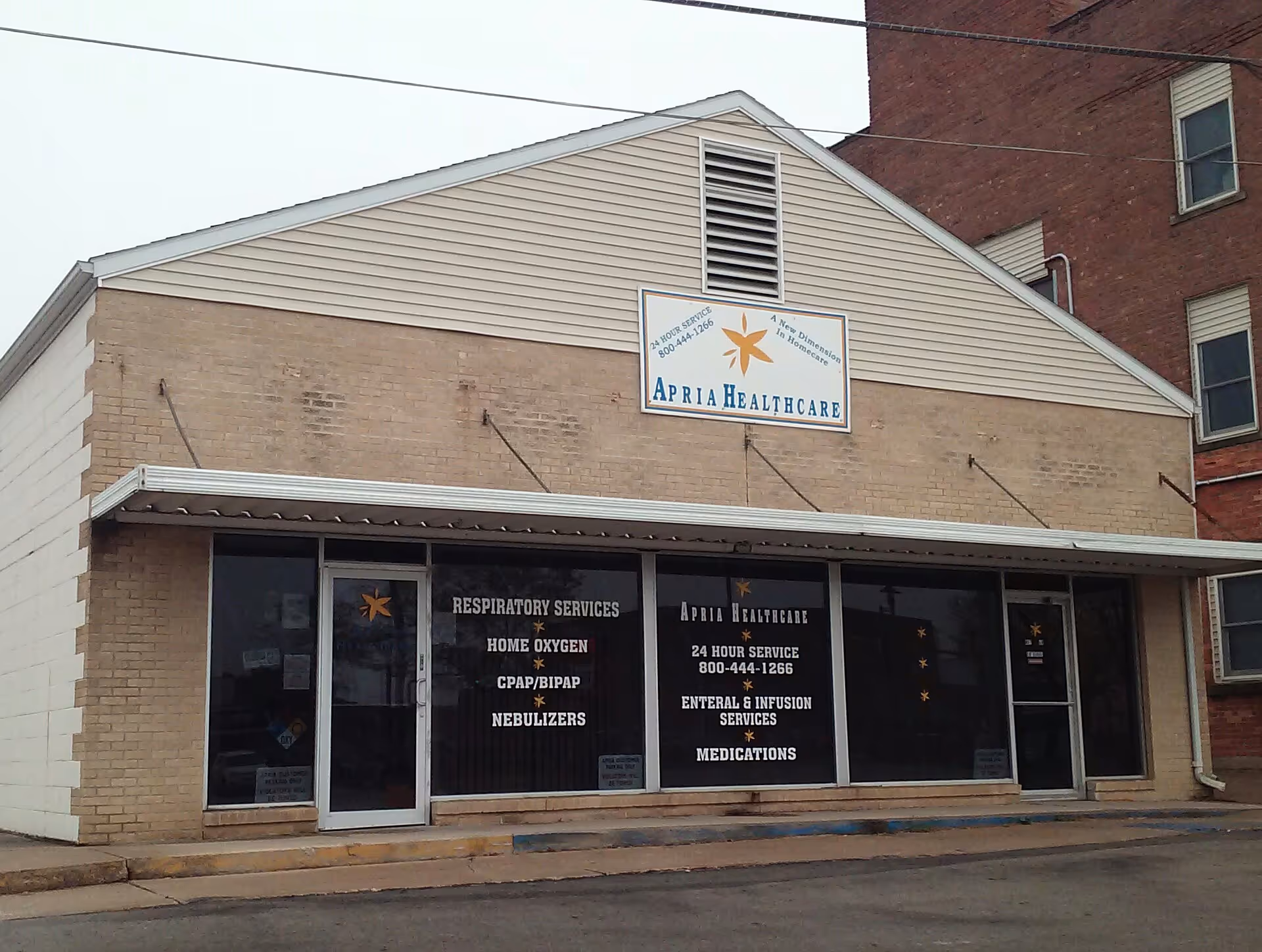 Exterior view of Apria Healthcare storefront with service listings on windows.