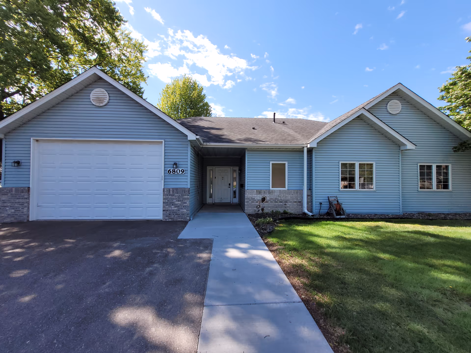 Blue single-story facility with a two-car garage and walkway to the entrance.